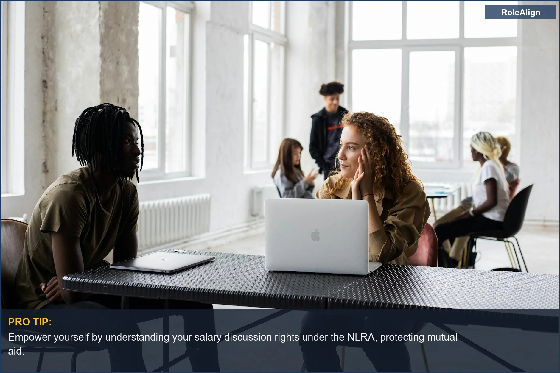 Concentrated coworkers in a loft workspace discussing project details, a protected activity.