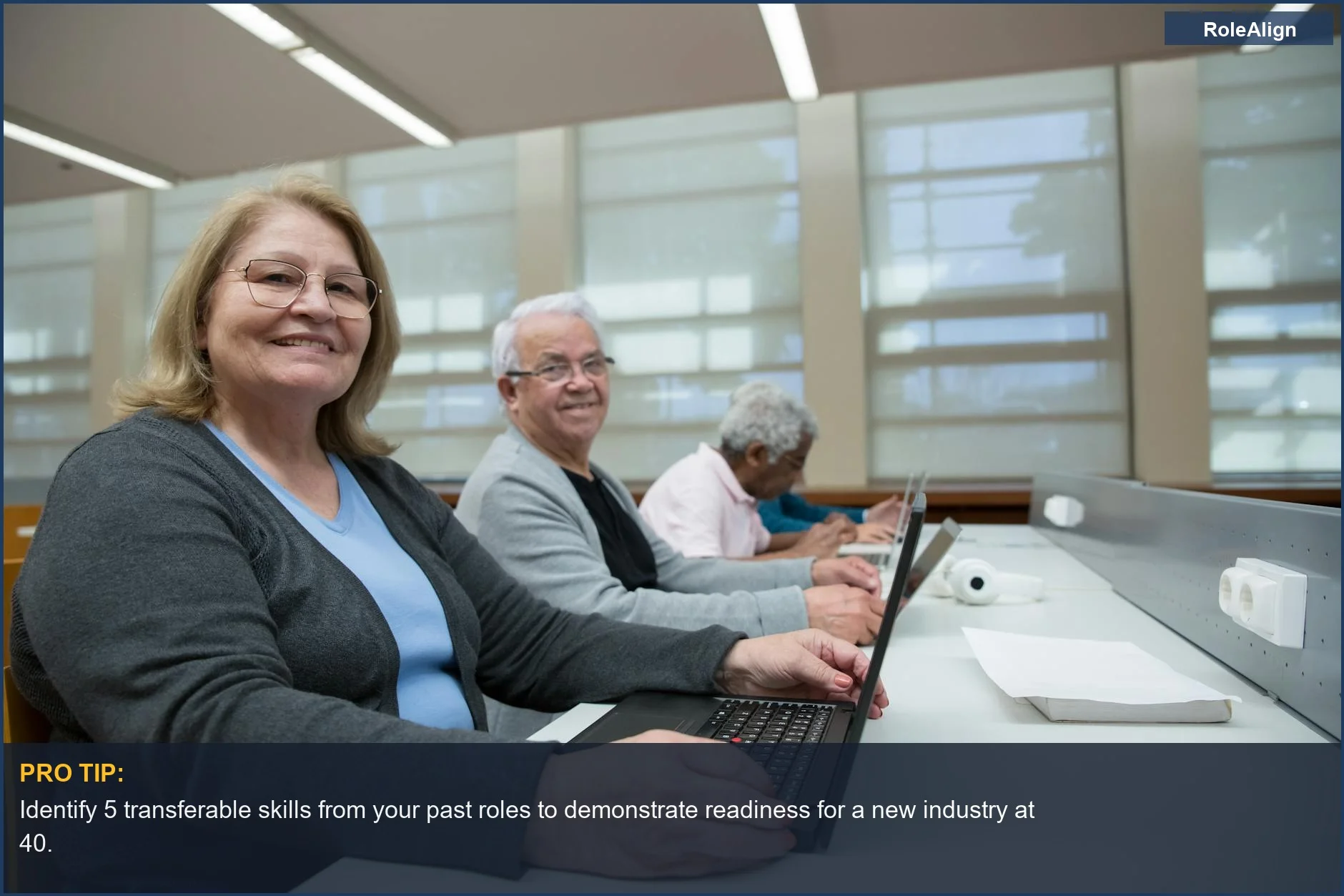 Smiling seniors learn computer skills in modern classroom, ideal for career change at 40.