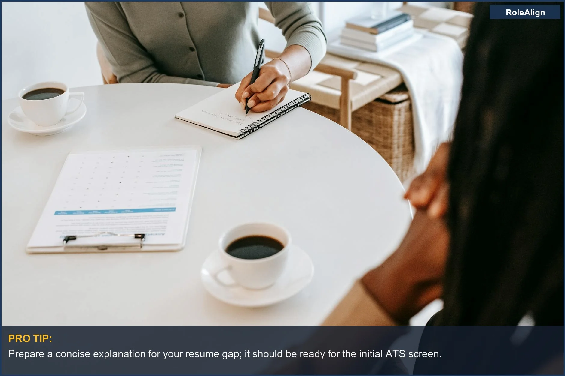Multiracial female interviewer questions a Black man during a job interview with coffee on the table.