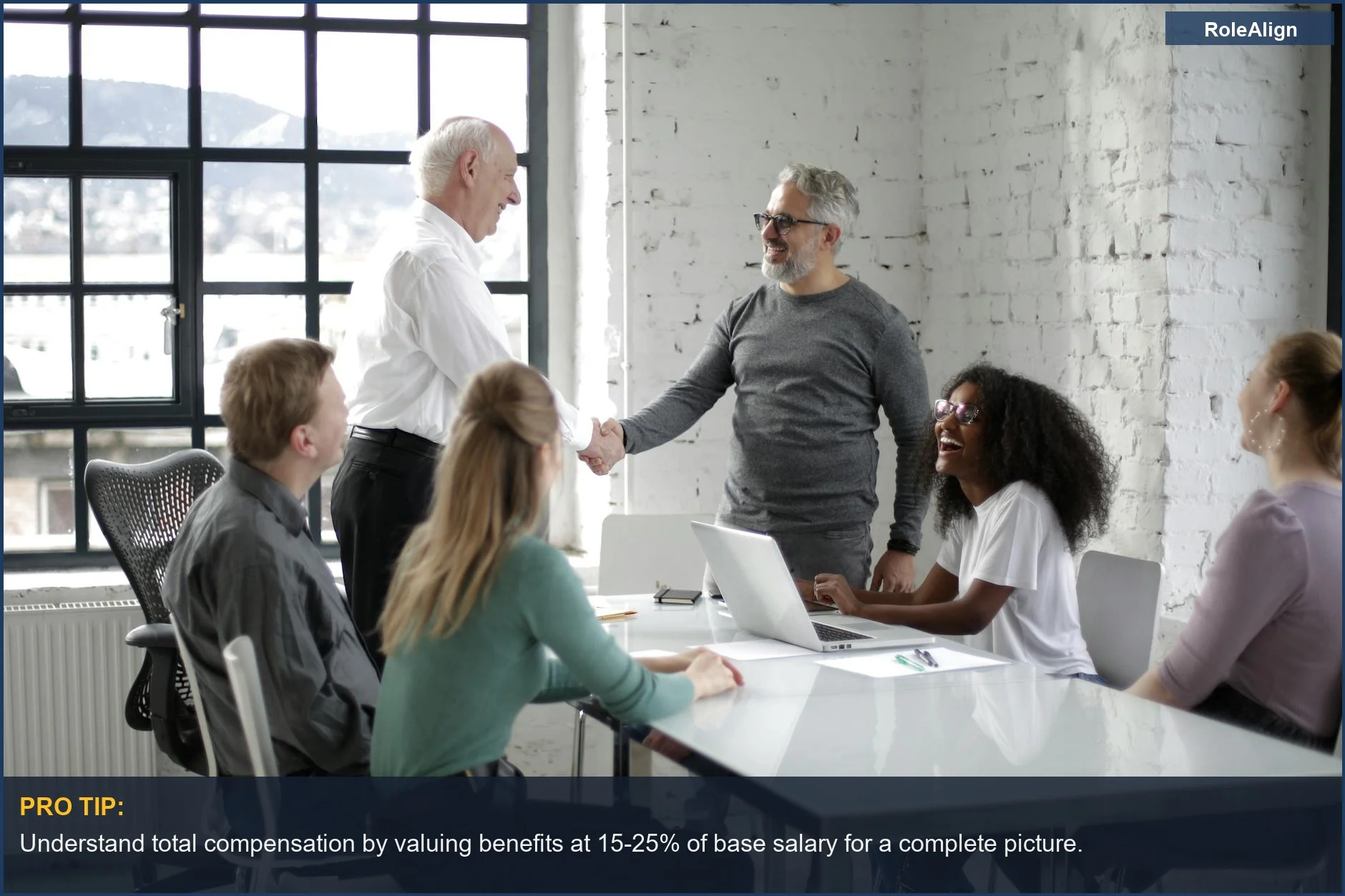 Cheerful colleagues shaking hands, symbolizing successful negotiations on employee compensation and benefits.