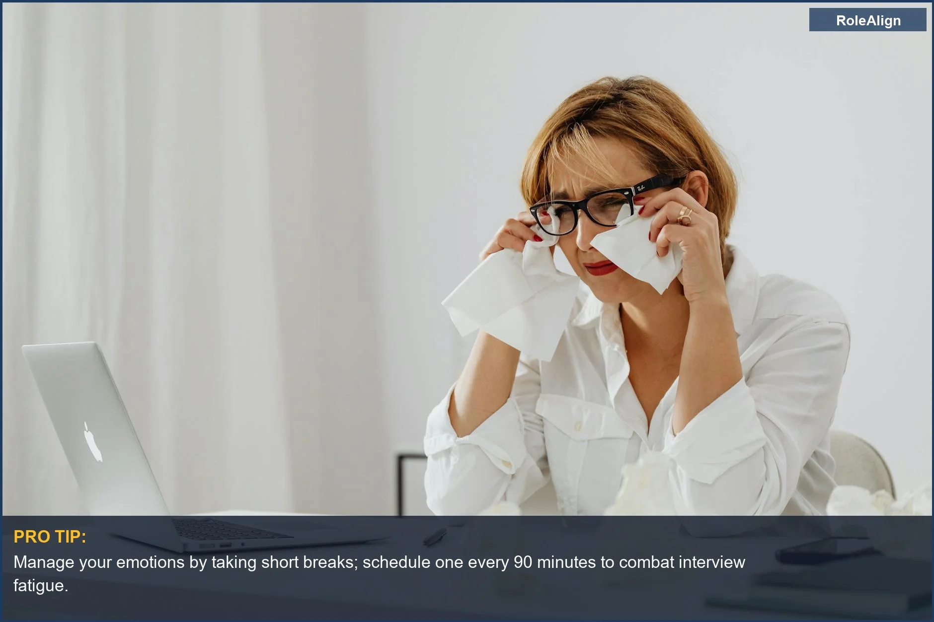 Woman feeling stressed after being ghosted after final interview, with tissues nearby.