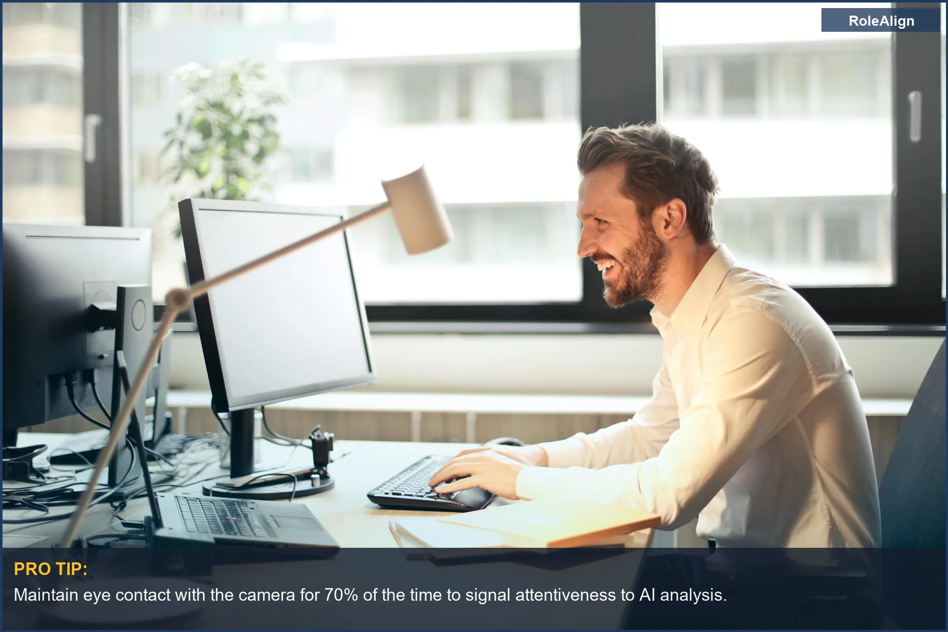Hombre sonriendo en un escritorio de oficina con una computadora, ilustrando herramientas de preparación de entrevistas con IA que analizan señales no verbales positivas.