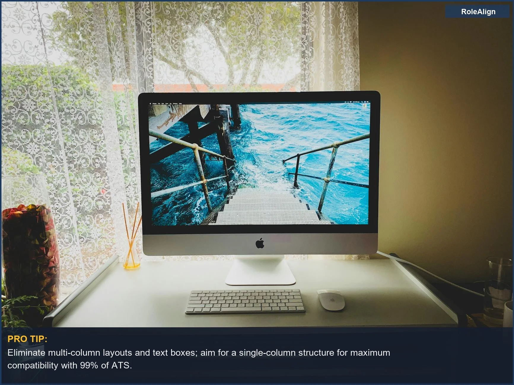Elegante configuración de computadora junto a una ventana, simbolizando la necesidad de formatos de currículum simples para evitar la confusión del escáner de IA.