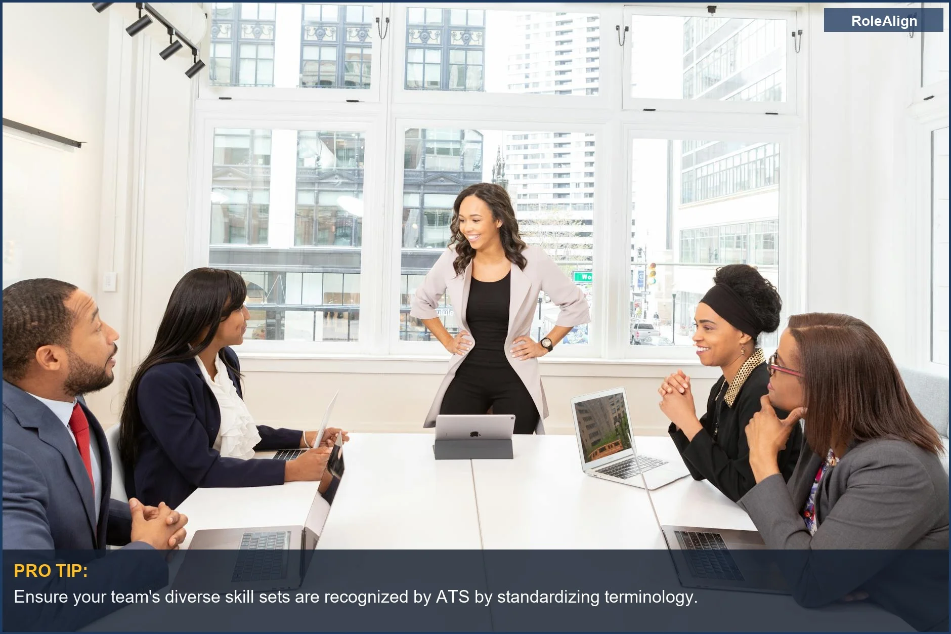 Diverse business team collaborates on laptops, reflecting modern hiring trends influenced by ATS evolution.