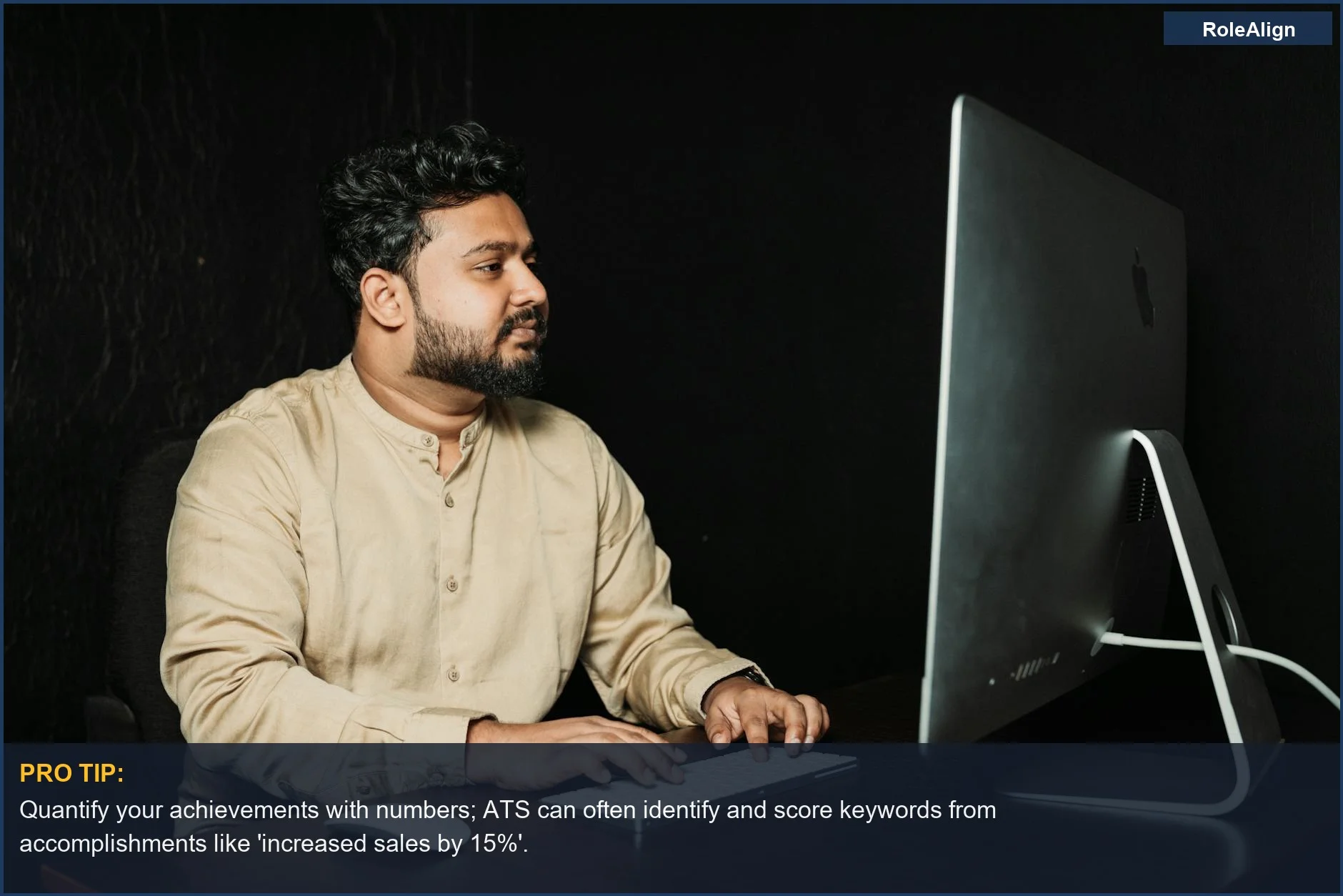 Man intently working on a computer in a dark office, demonstrating the efficiency of ATS in parsing applications.