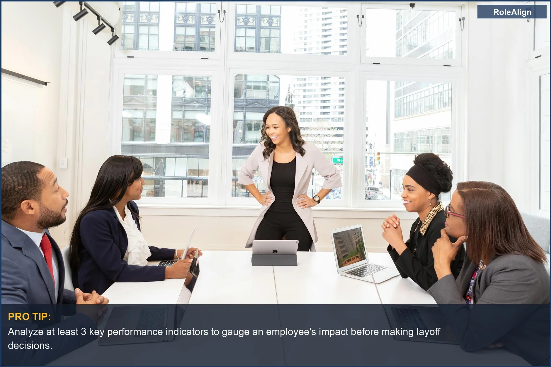 Diverse business team in a modern office discusses layoffs, considering company needs over individual performance.