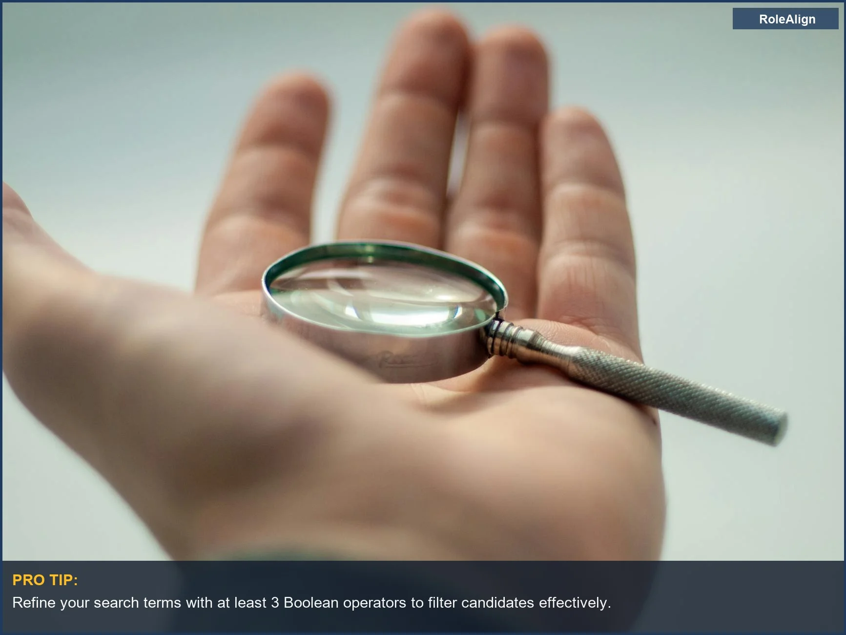 Hand holding a magnifying glass, emphasizing the precision in LinkedIn Recruiter boolean search tips.