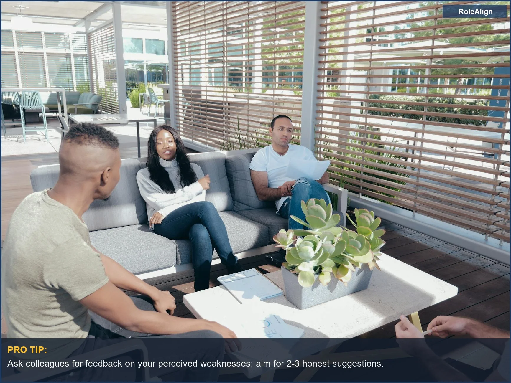 Diverse team collaborating in an office lounge, discussing how to frame your weakness interview answer.