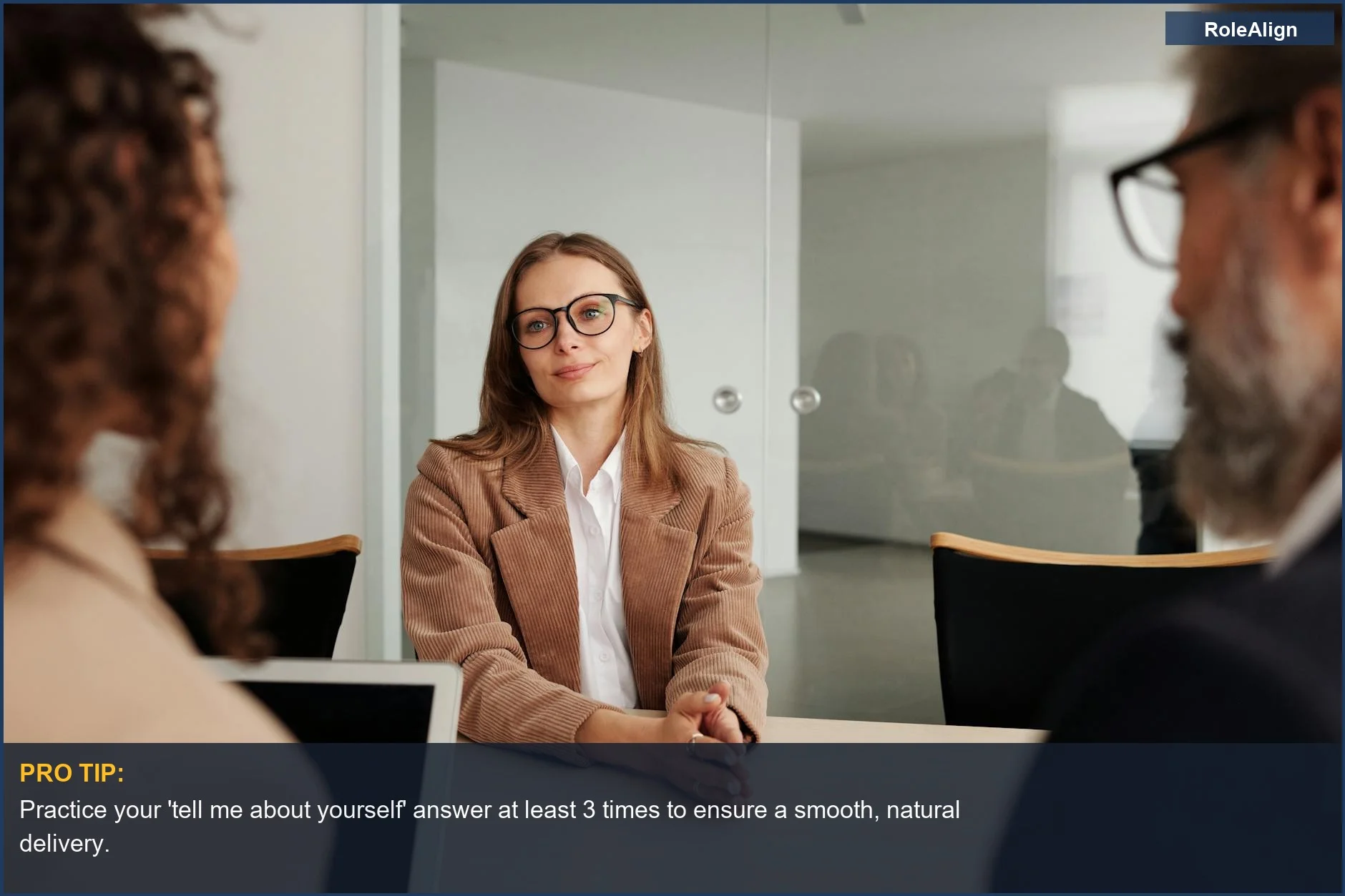 Young woman confidently attending a job interview, preparing her 'tell me about yourself' response.
