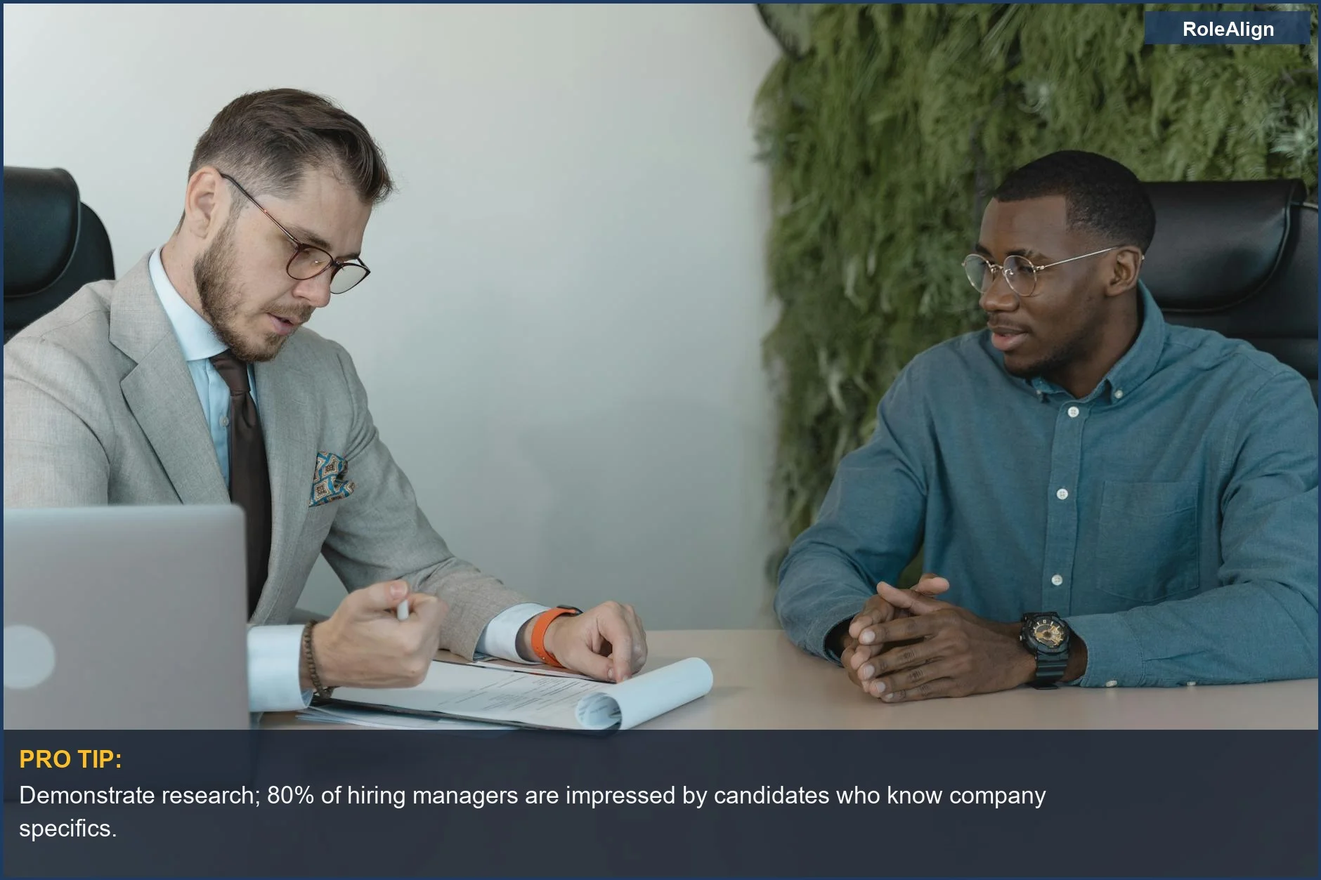 Two men in a professional job interview, discussing why one is leaving his current position.