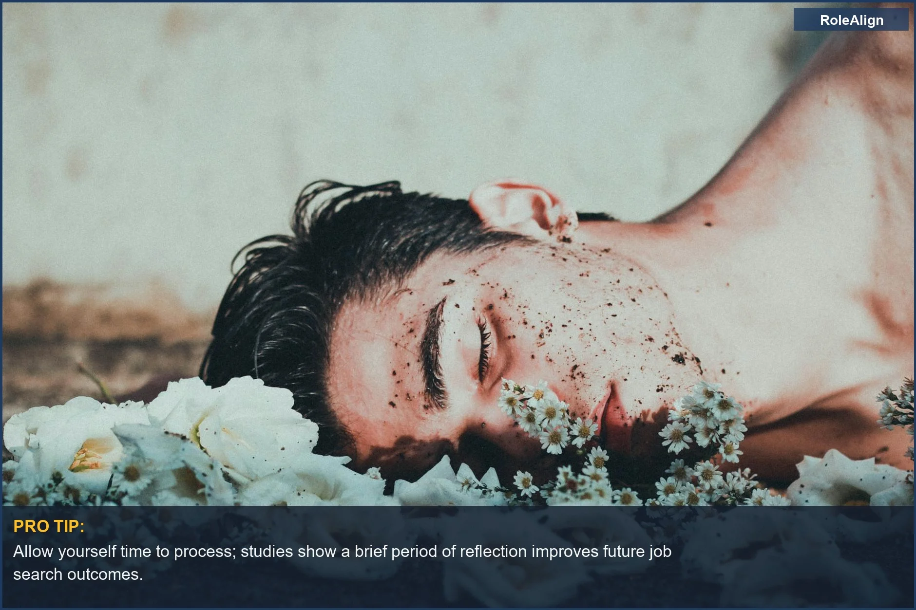 Man lying among flowers in introspection after being rejected from a job opportunity.