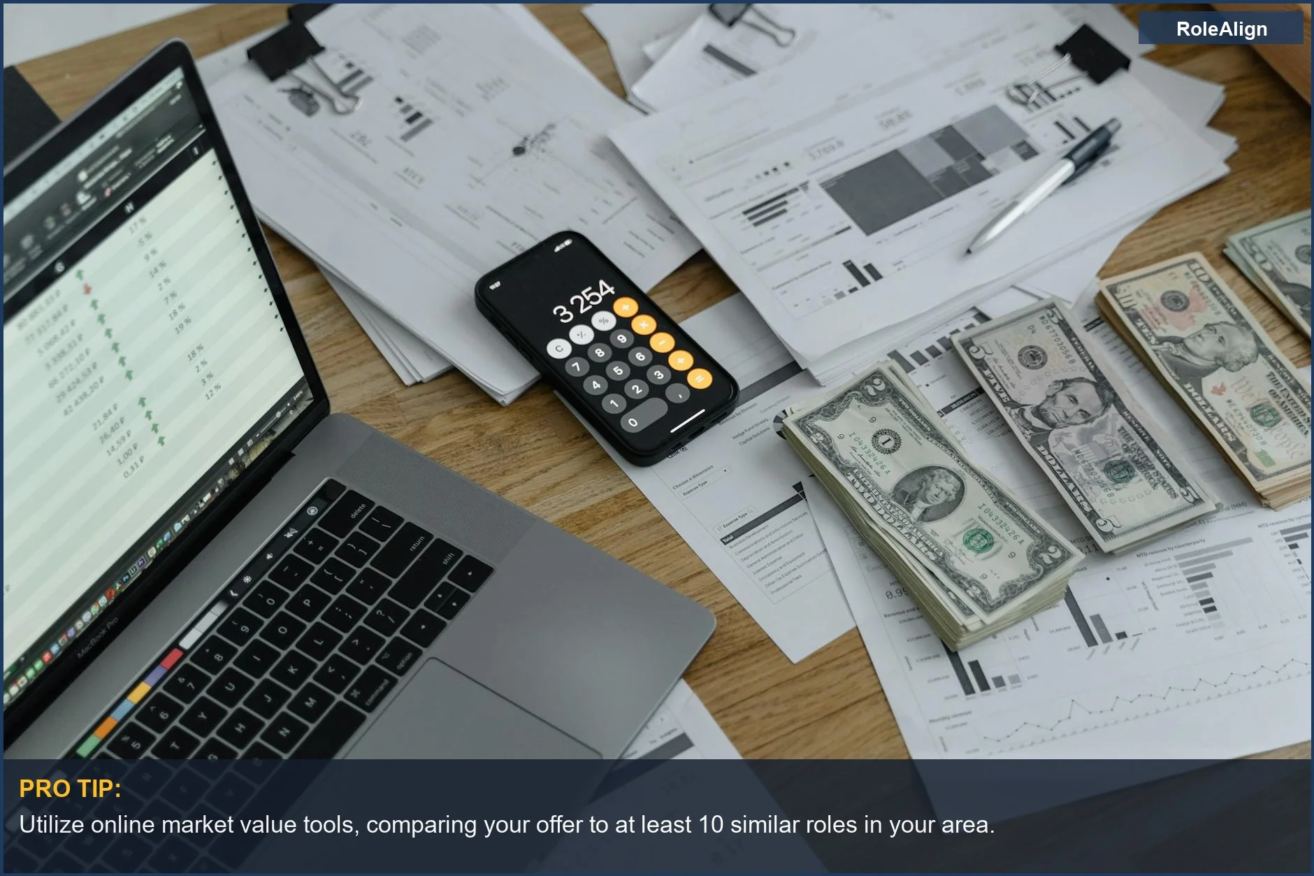 Desk with financial documents, calculator, and laptop, symbolizing research for a job offer's true market value.