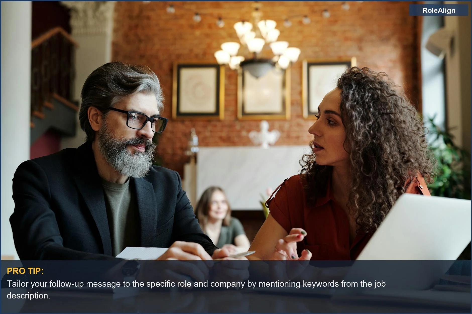 Two business professionals strategizing over a laptop, demonstrating focused discussion for a successful post-interview follow-up.