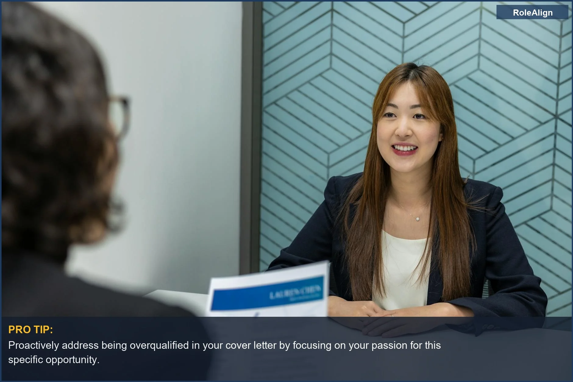 Confident young woman in a business meeting with an interviewer, addressing her overqualified interview concerns.