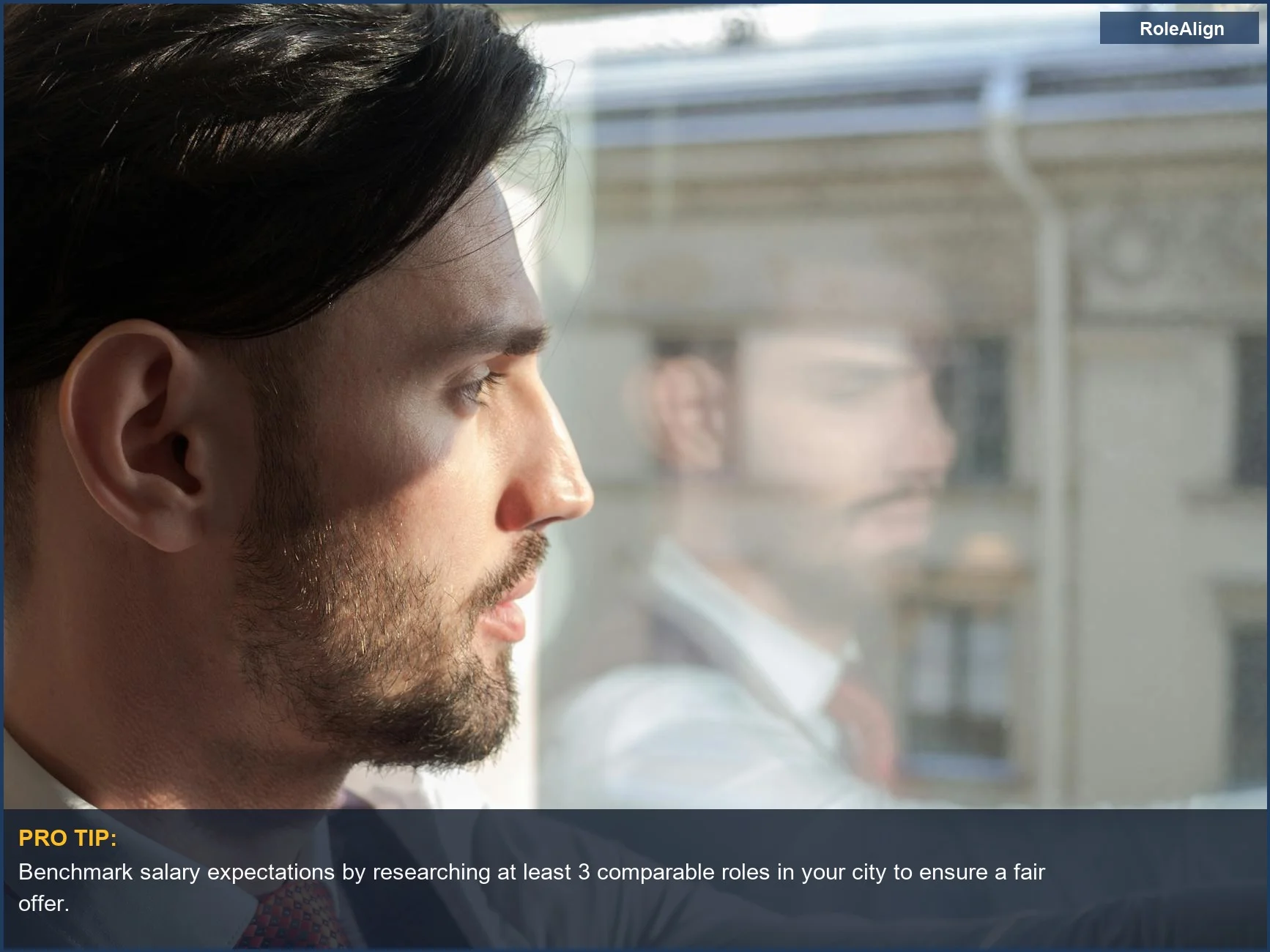 Businessman looking out window, contemplating the next career move after evaluating a job offer.