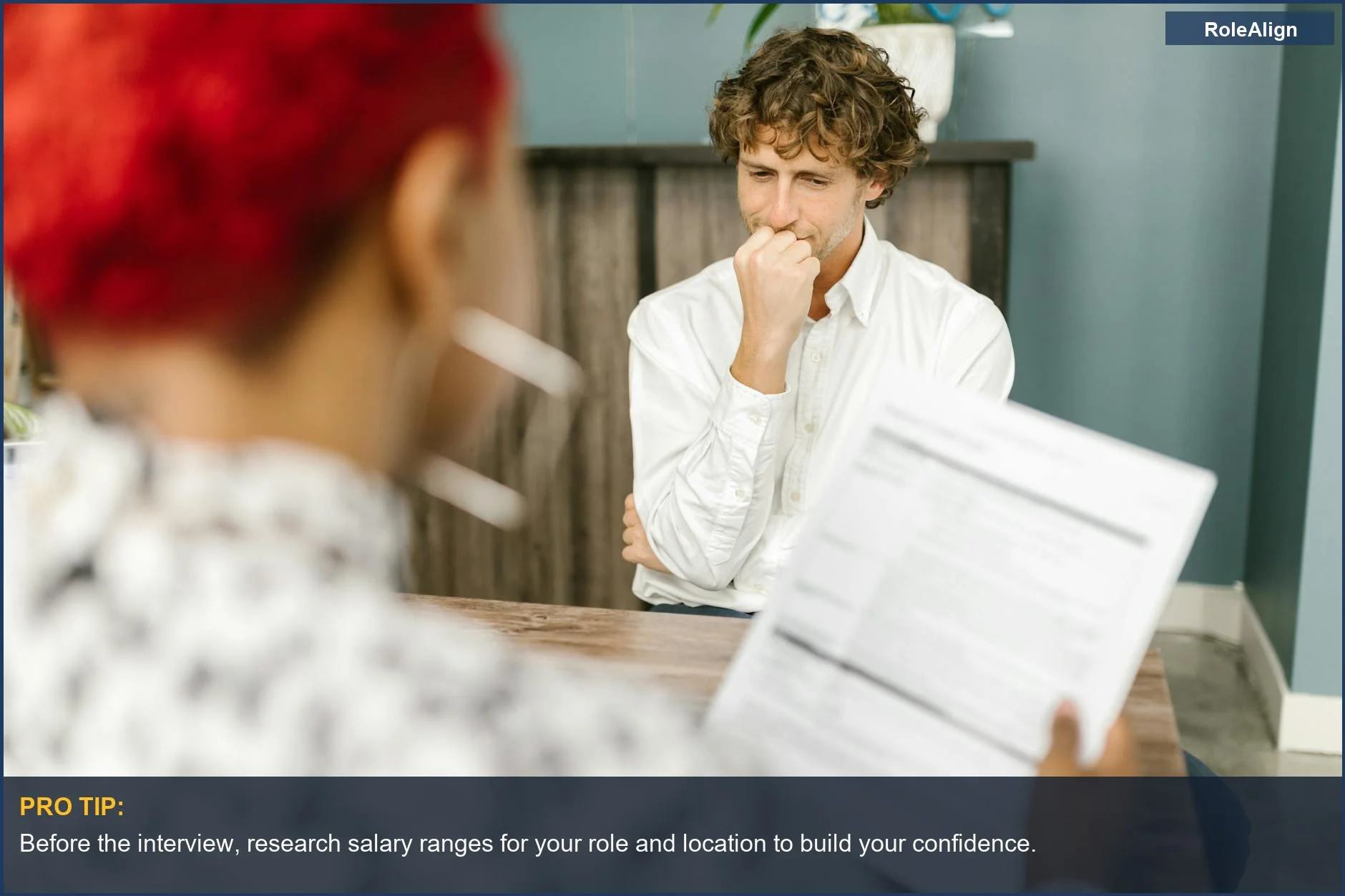 Man thoughtfully considering his next move during a job interview, preparing to negotiate salary.