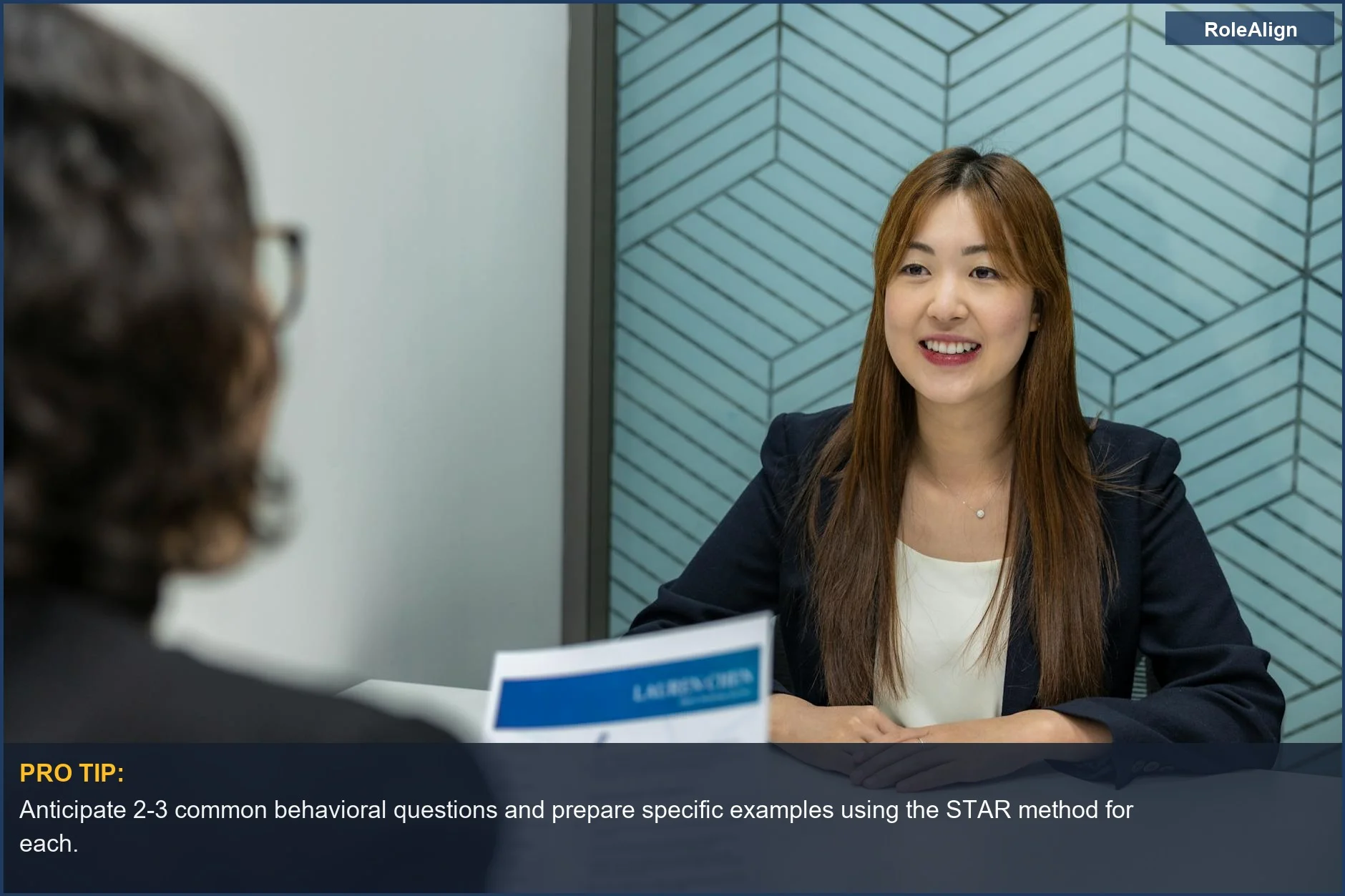 Confident young woman in a business meeting, preparing for behavioral questions with clear communication.