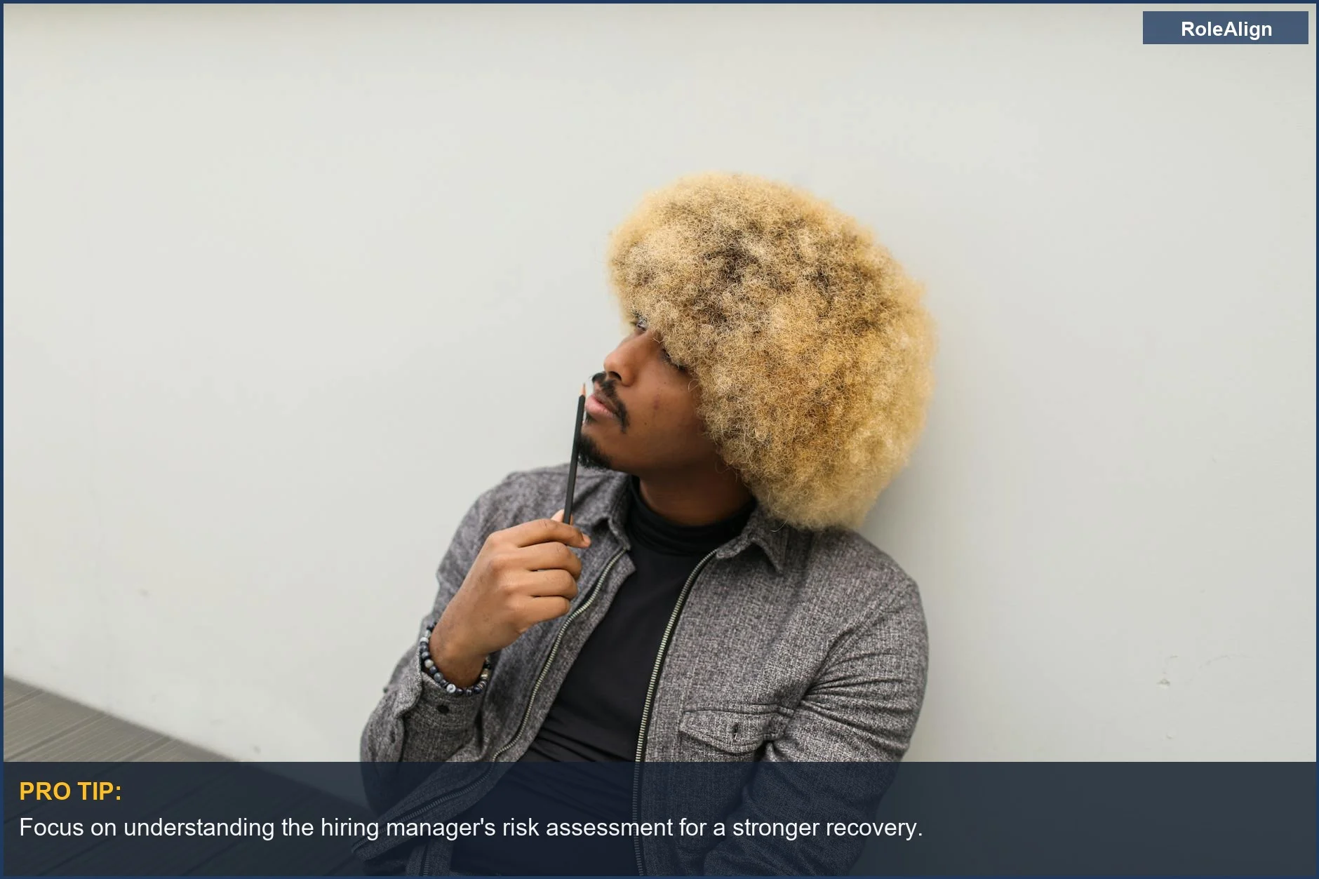 Hombre joven con afro pensando detenidamente en estrategias de recuperación de entrevistas después de una mala respuesta a una pregunta.