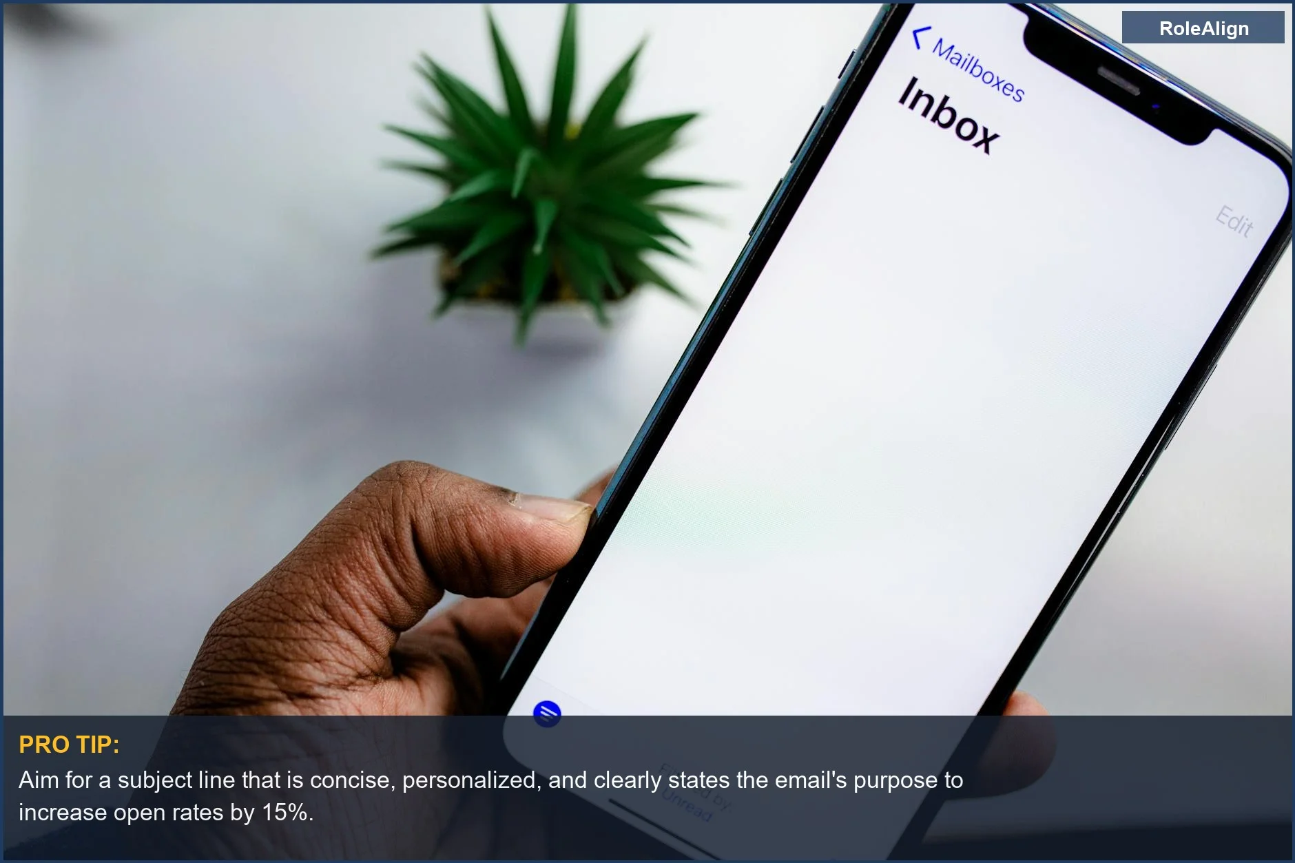 Close-up of a hand holding a smartphone displaying an email inbox, highlighting the importance of cold email tips.