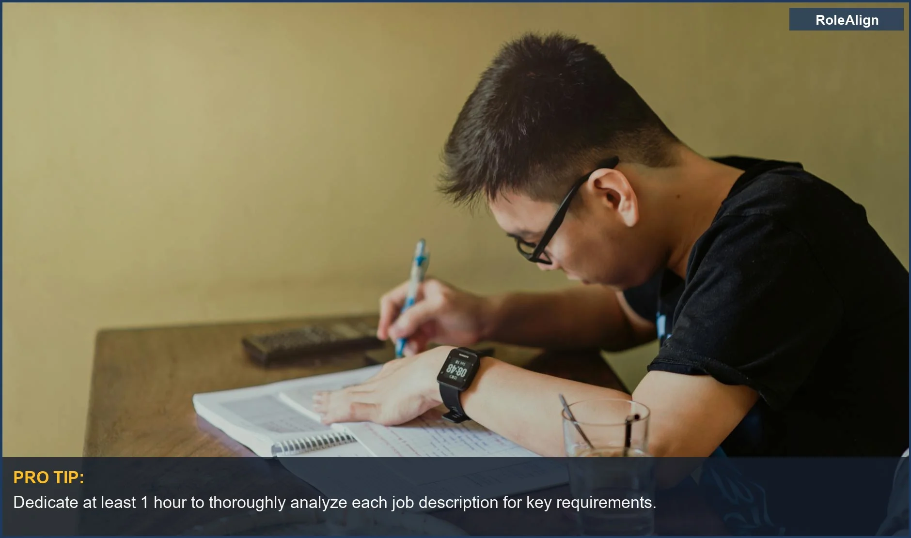 Young man studying intensely at his desk, taking notes for his resume with no experience.