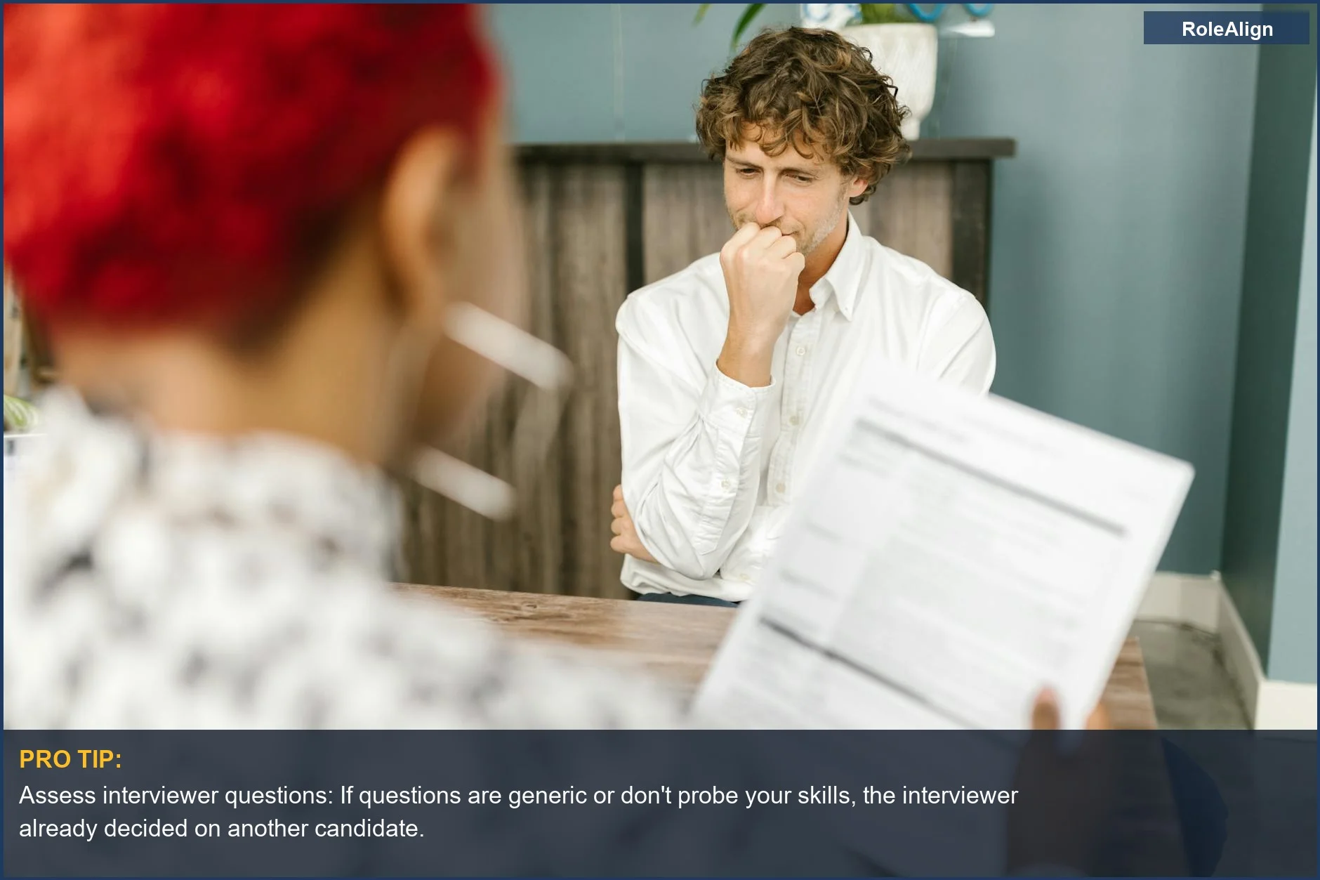 Man in an office setting, reflecting thoughtfully during a job interview, contemplating if the interviewer already decided.