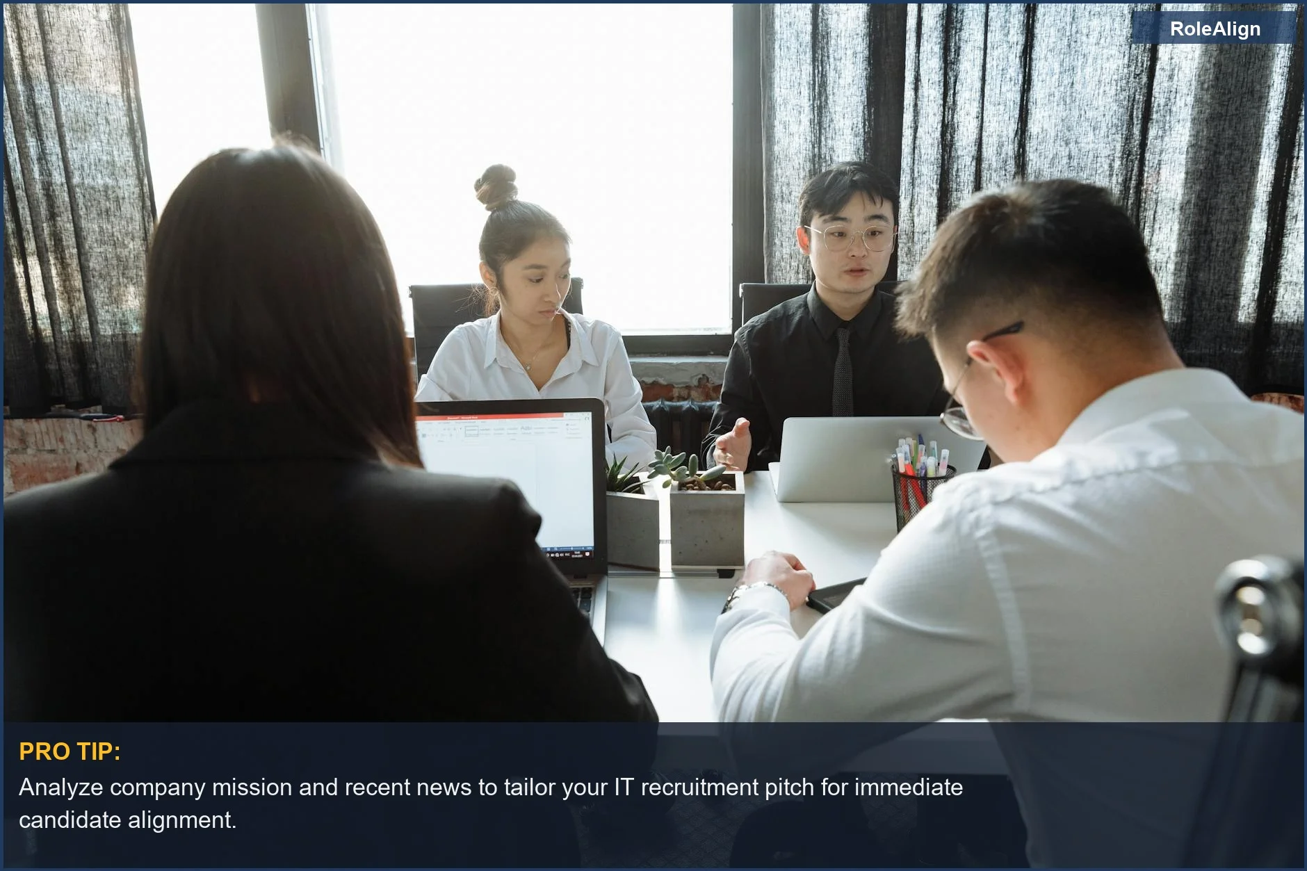 Focused IT professionals working with laptops in a bright office, representing the analytical approach in tech recruitment.