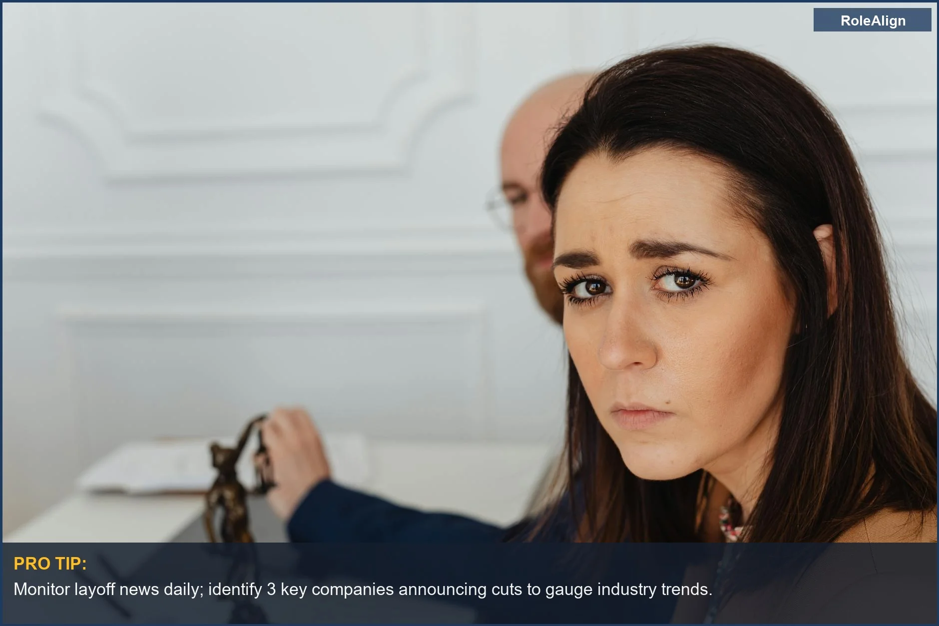 Worried woman in office, looking at camera, illustrating effects of 2025 job cuts.