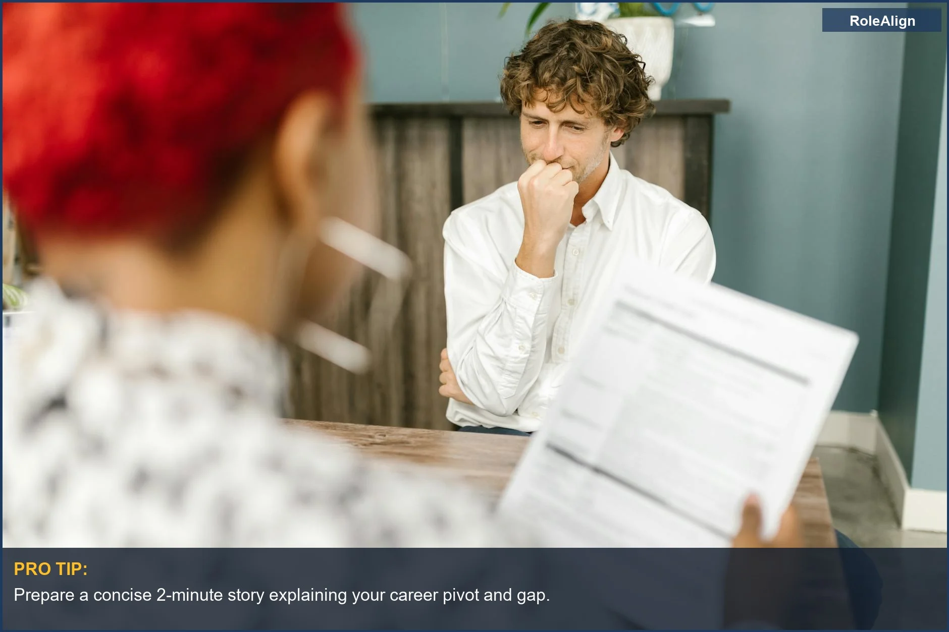 Candidato pensativo en una entrevista, considerando cambios de carrera y gestionando lagunas en el currículum.