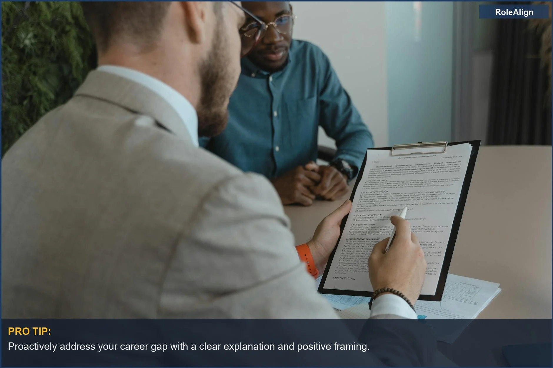 Reclutador examina documentos de candidatos, comprendiendo las lagunas laborales en el proceso de contratación.