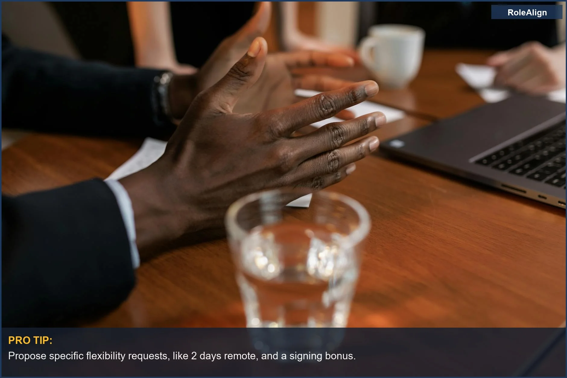 Close-up of diverse hands in a meeting, gesturing during a discussion about work flexibility.