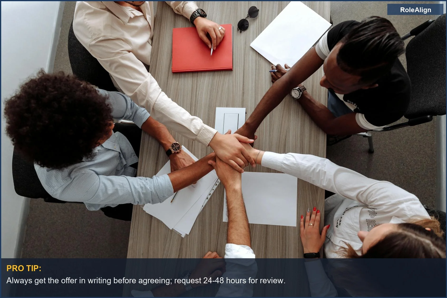 Overhead view of diverse hands uniting, representing agreement on flexible work arrangements and benefits.