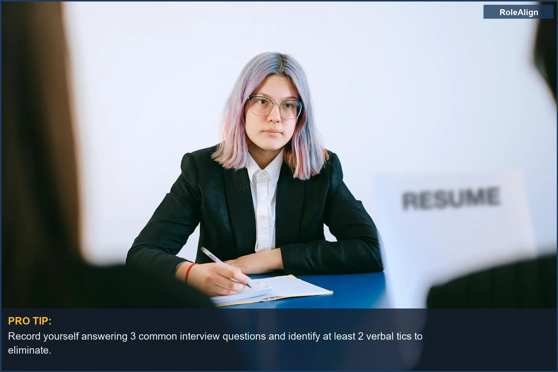 Joven en traje tomando notas durante una entrevista de trabajo, preparándose para la actuación.