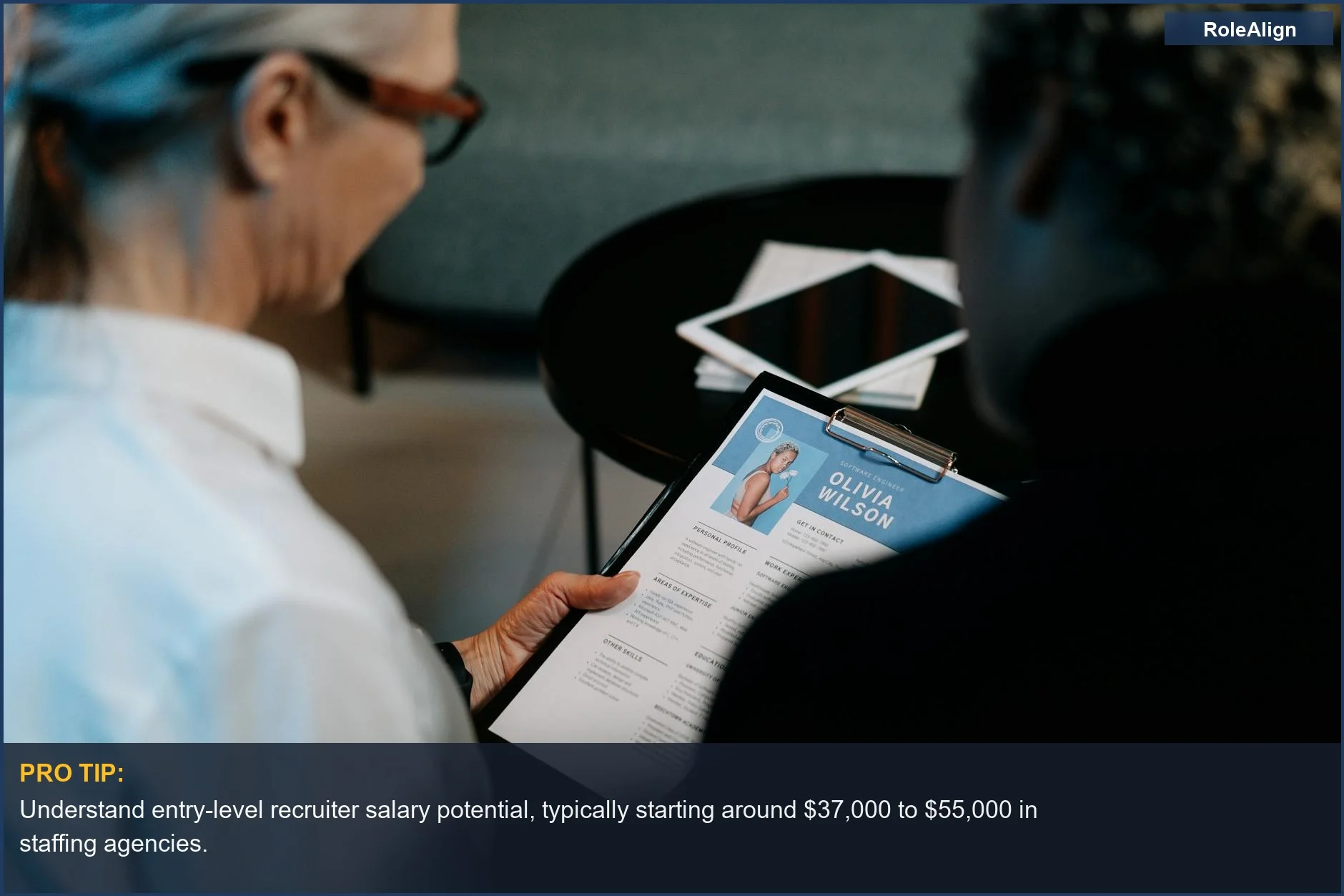 Business professionals interviewing a candidate with a resume, showing entry-level recruiter salary expectations.