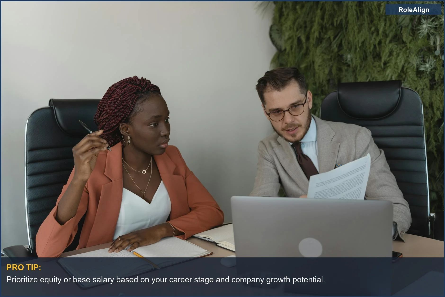 Two professionals discussing documents and ideas during a modern office meeting.