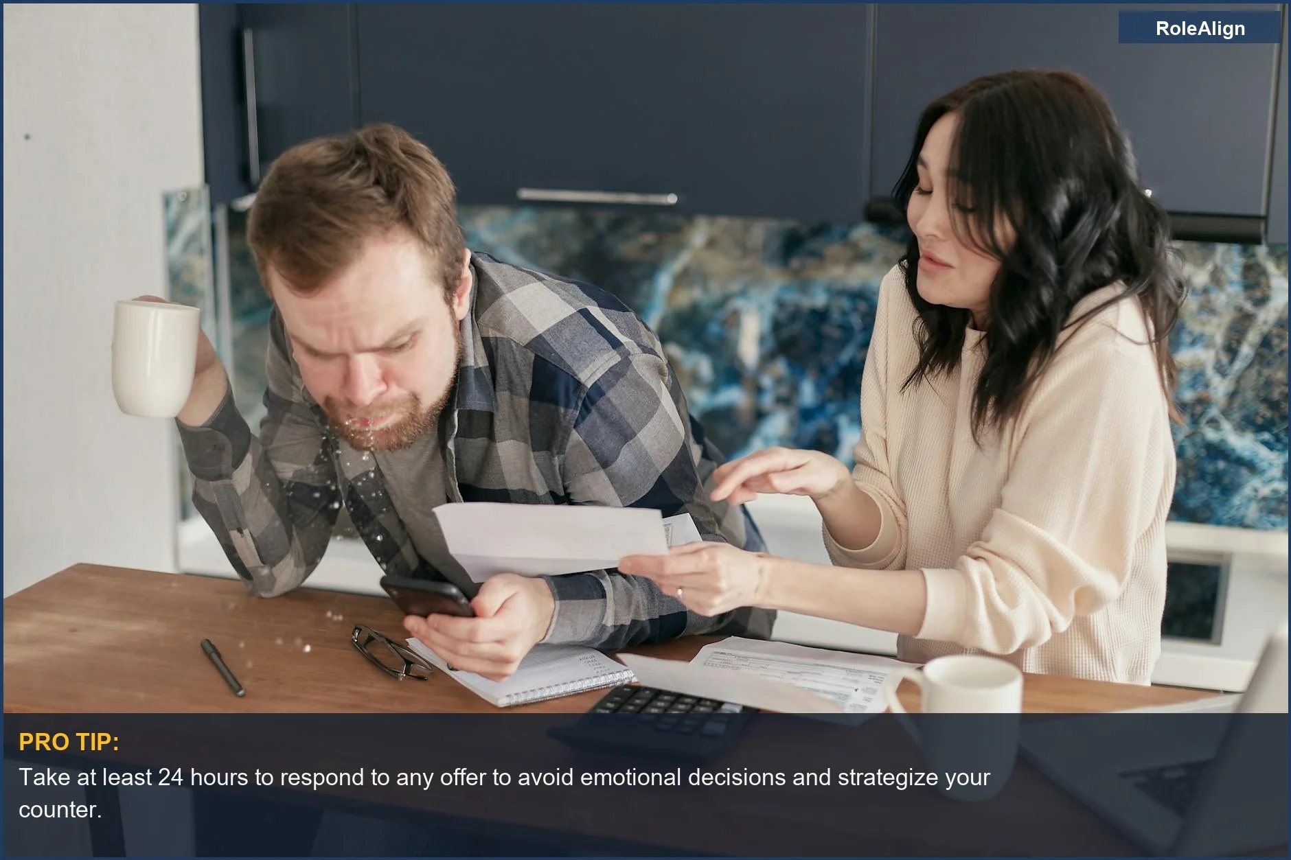 Worried couple reviewing bills and expenses with a calculator and laptop, signifying the financial impact of a lowball offer.