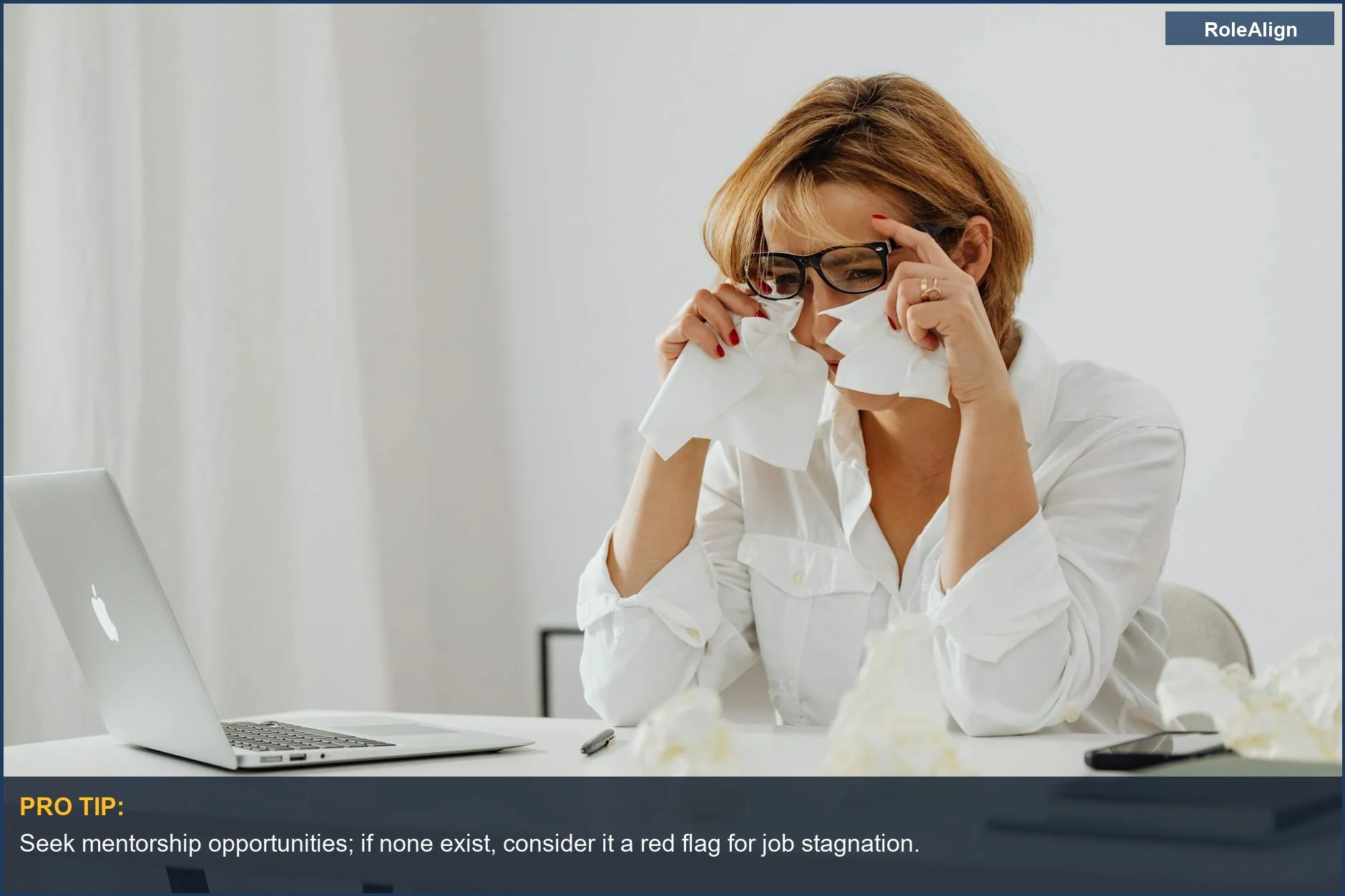 Woman crying at her desk with tissues, signifying the emotional toll of a no growth job.