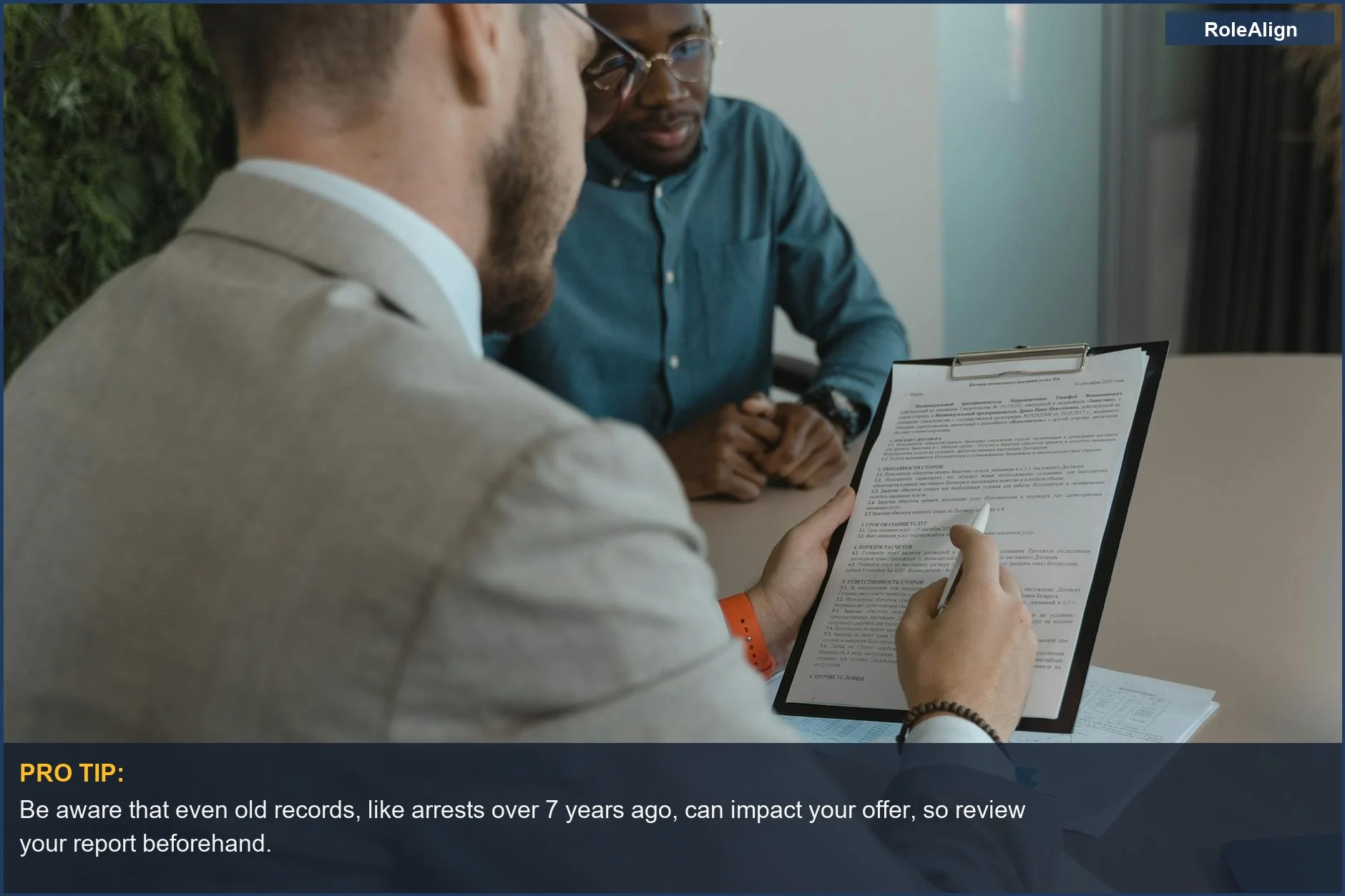 Recruiter reviewing candidate documents during a job interview, demonstrating the impact on a background check job offer.