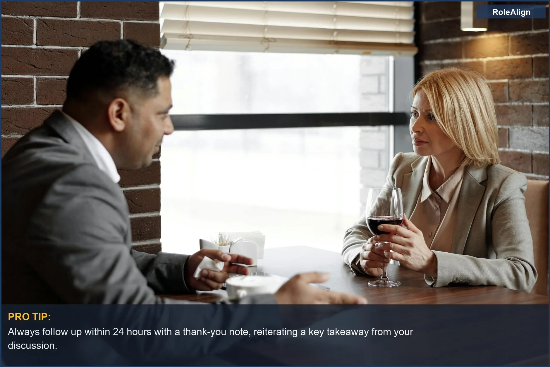 Business professionals discussing ideas over wine, highlighting strategic contact initiation for informational interviews.