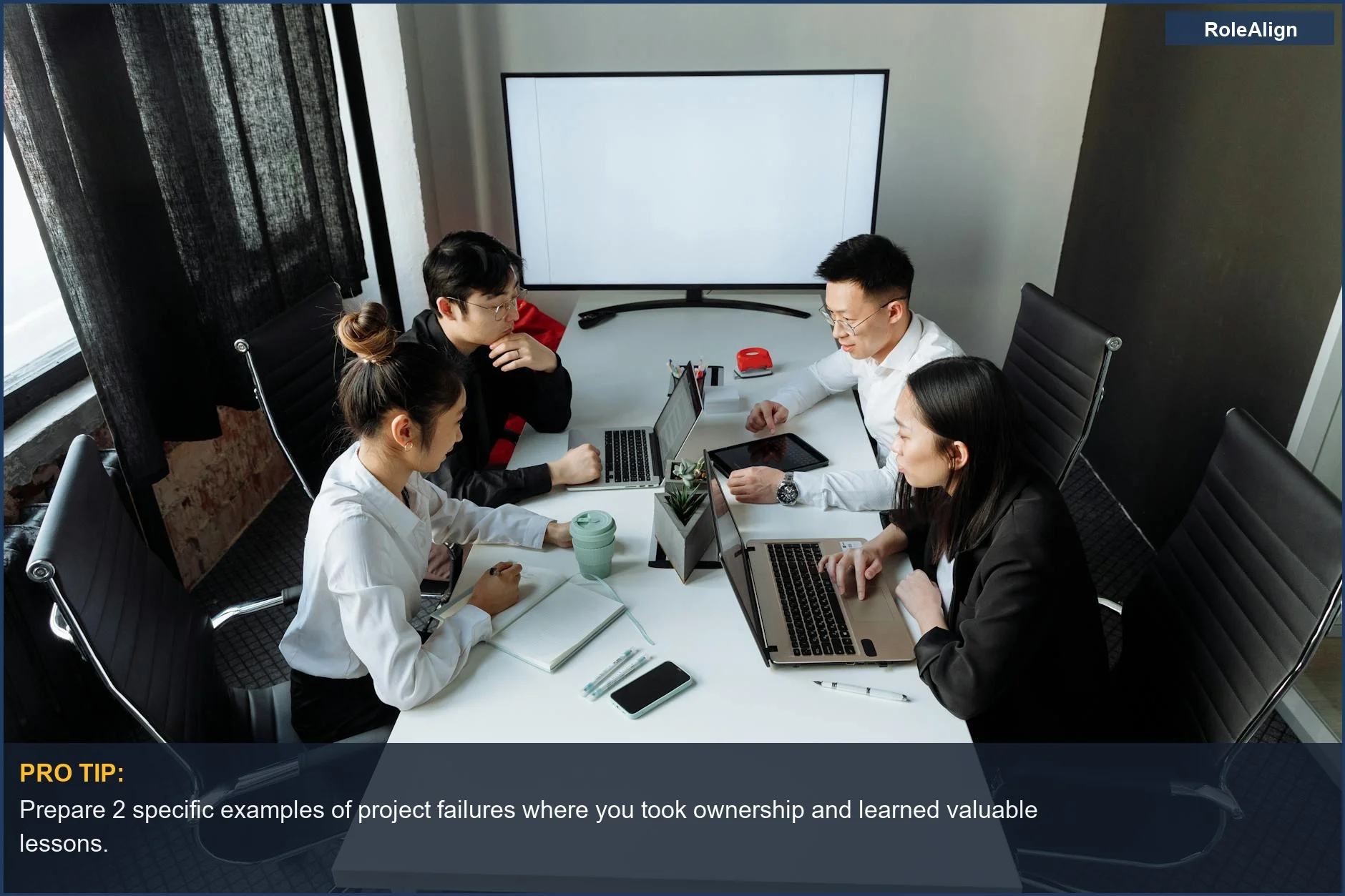 Professionals collaborating on laptops, revealing what interviewers look for in handling project failures.