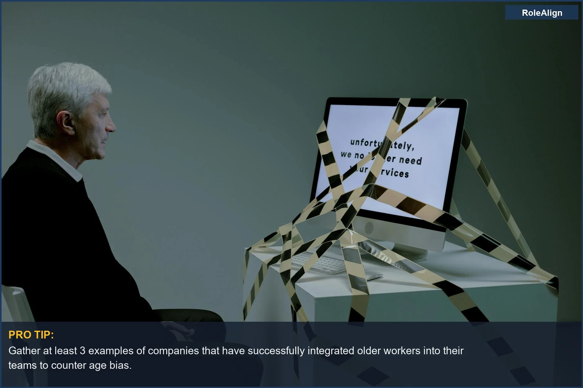 Hombre mayor mirando una pantalla de computadora con un mensaje de pérdida de empleo, destacando la discriminación por edad en la contratación y el rechazo por sobrecualificación.