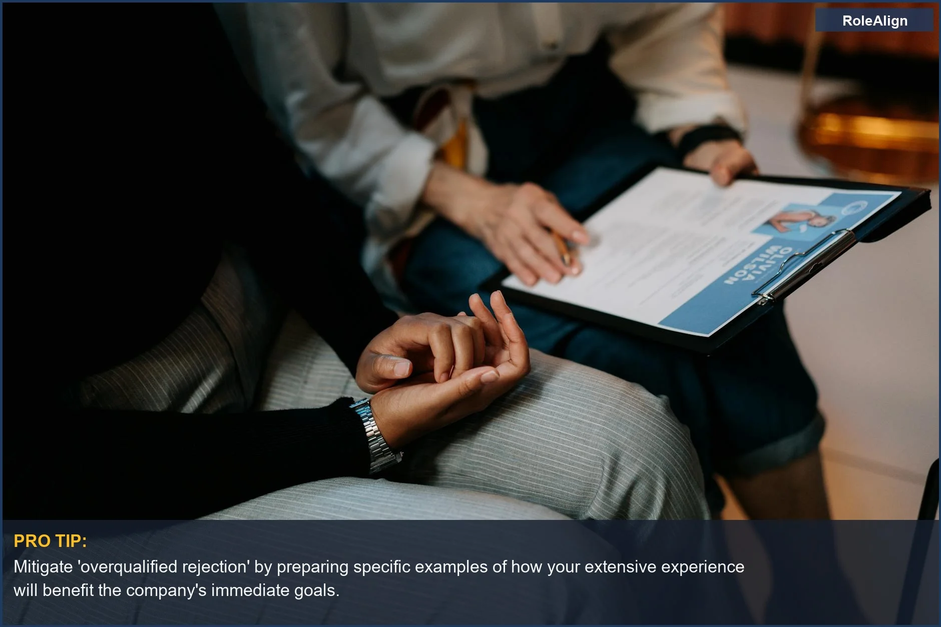 Two professionals reviewing a resume, illustrating the 'overqualified rejection' scenario and its underlying reasons.