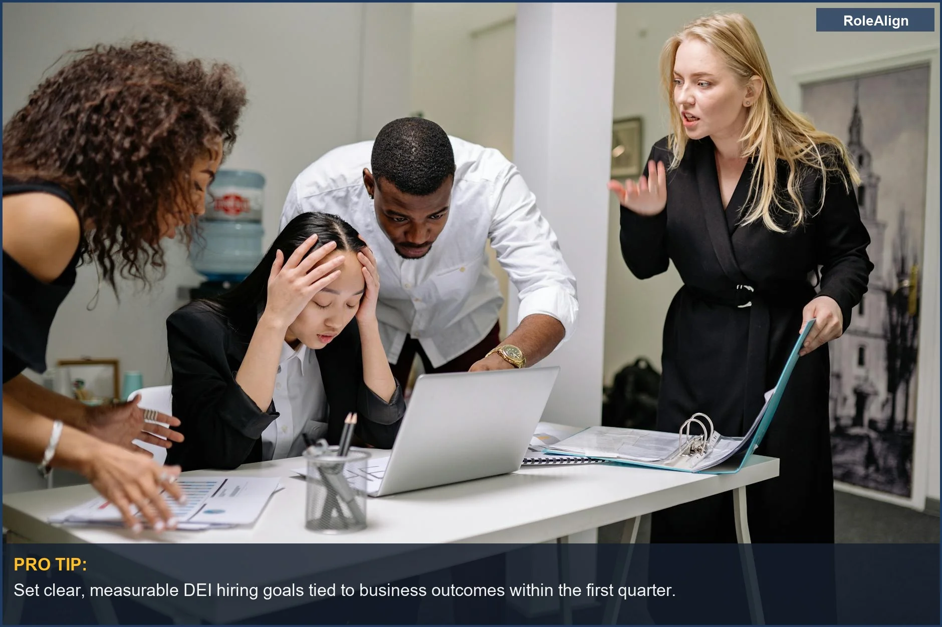Diverse colleagues in heated office discussion around laptop, illustrating DEI hiring challenges.