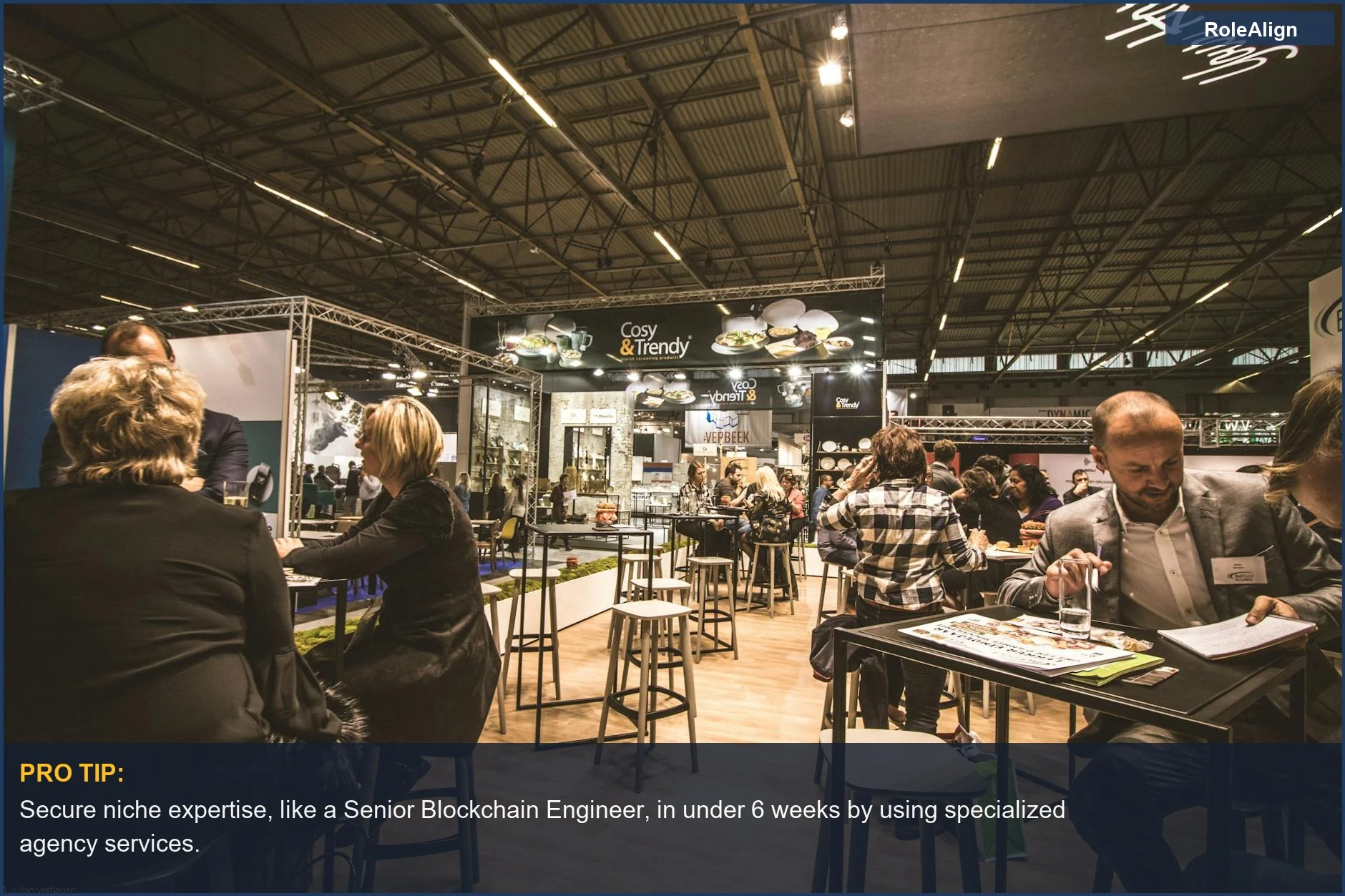 Bustling business expo with professionals networking, illustrating why companies hire recruitment agencies for specialized and urgent talent needs.