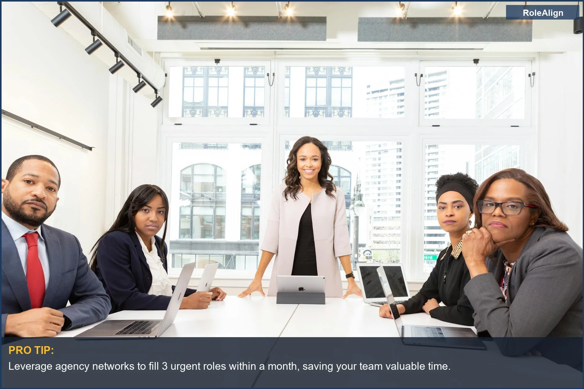 Diverse professionals in a modern office collaborate, highlighting why companies hire recruitment agencies for efficient talent acquisition.