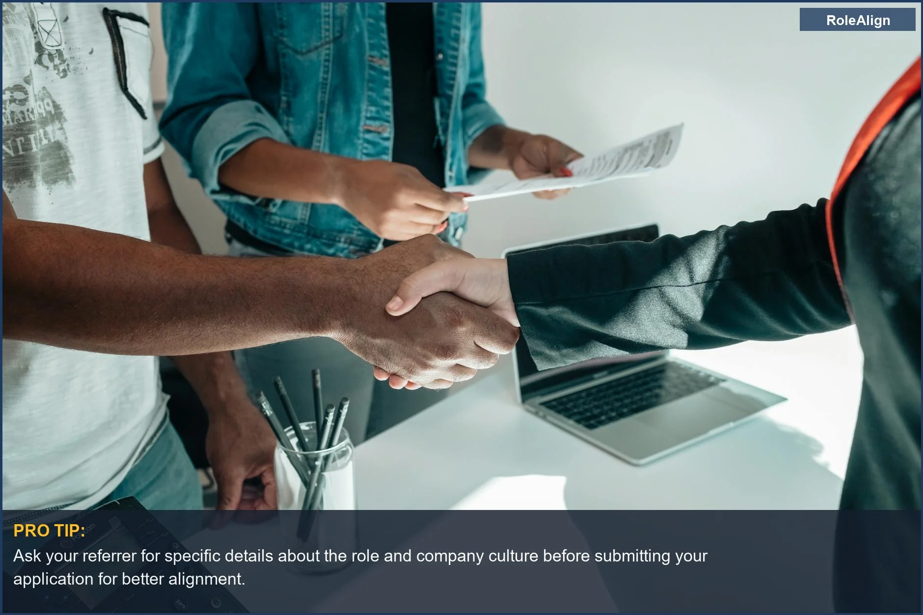 Business professionals in a modern office completing a handshake agreement, signifying a successful referral job search.
