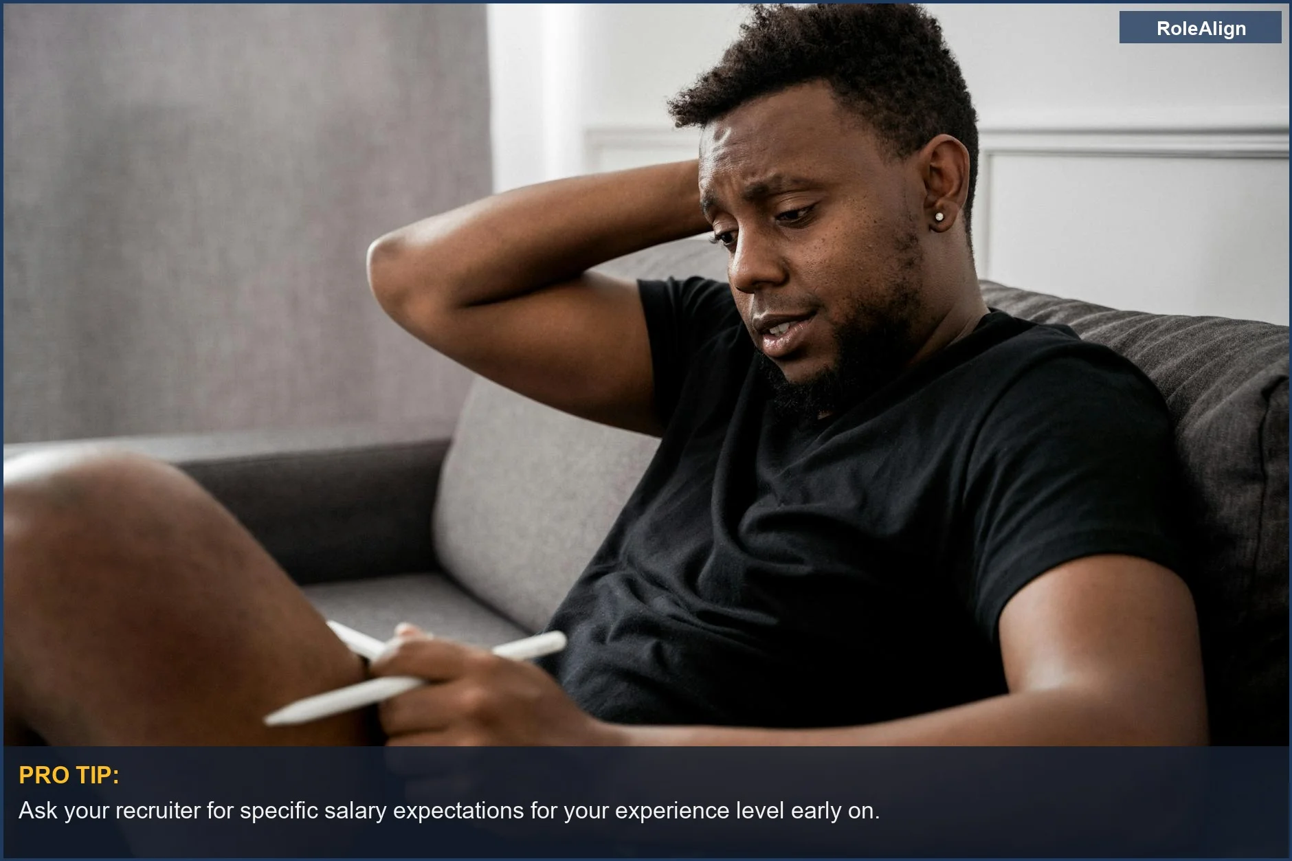 Man thoughtfully looking at a tablet, pondering the meaning behind a very broad salary range.