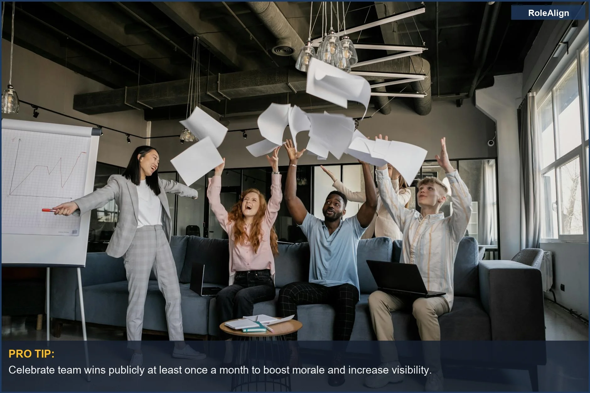 Happy diverse coworkers celebrating success by throwing papers, proving visibility matters for promotion.