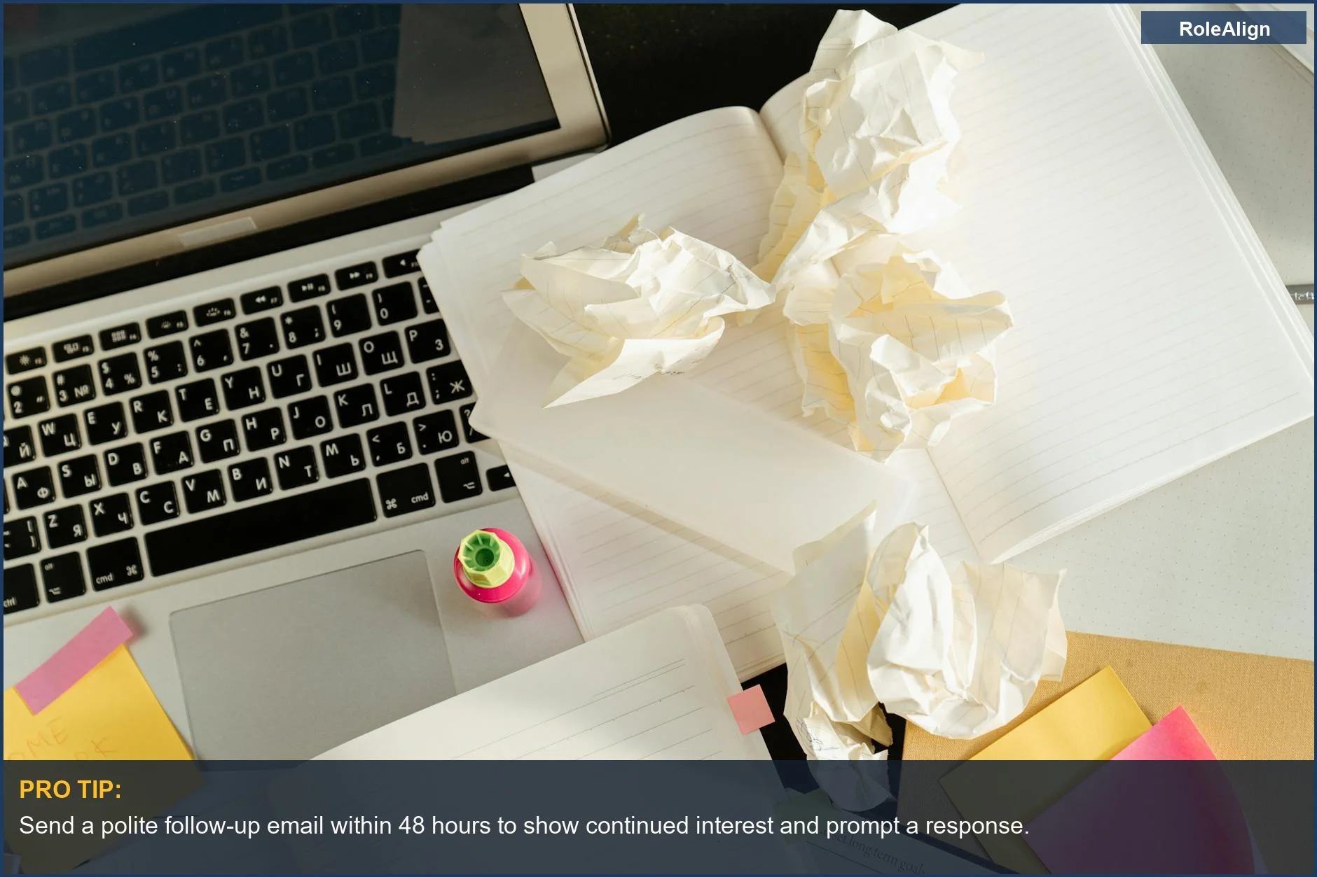 Cluttered desk with laptop and papers reflects the chaos behind why companies ghost after job interviews.