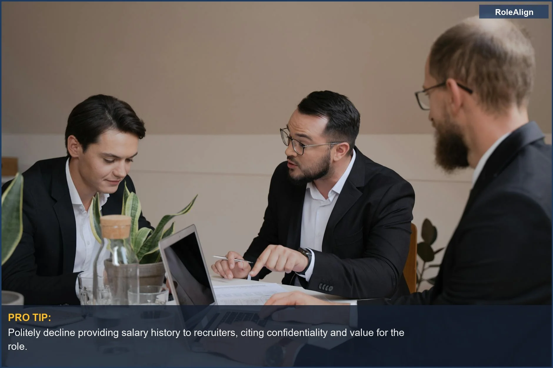Businessmen in meeting analyzing reports and laptop, a key moment to avoid discussing salary history.