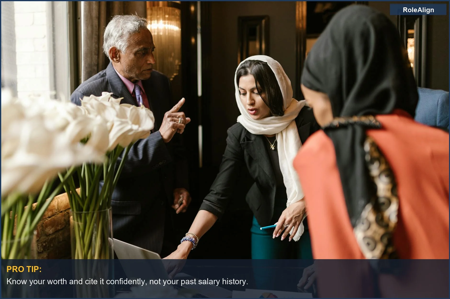 Diverse business professionals discussing work in an office, a situation where salary history can be misused.